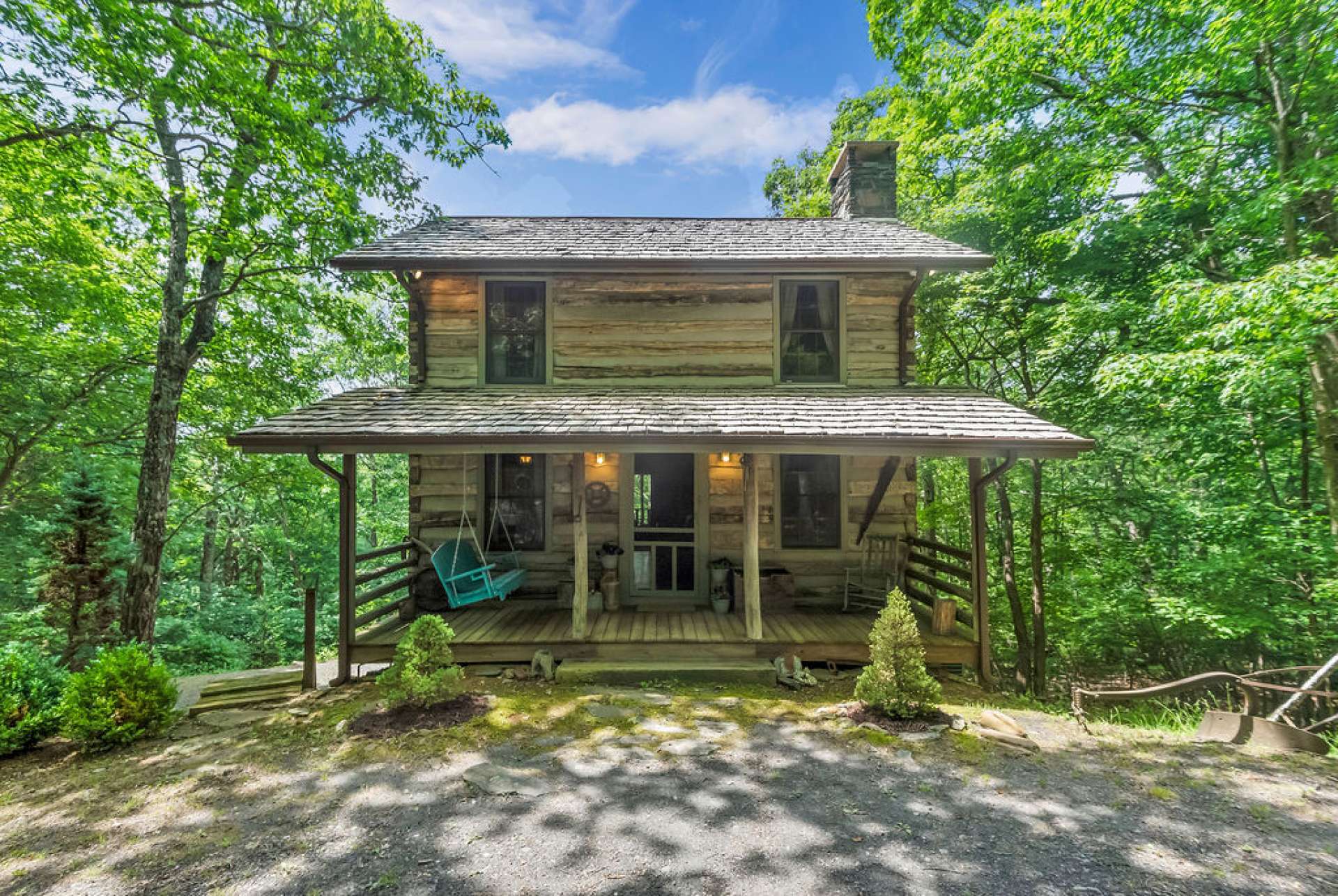 Stonebridge antique log home nestled in a wooded setting.