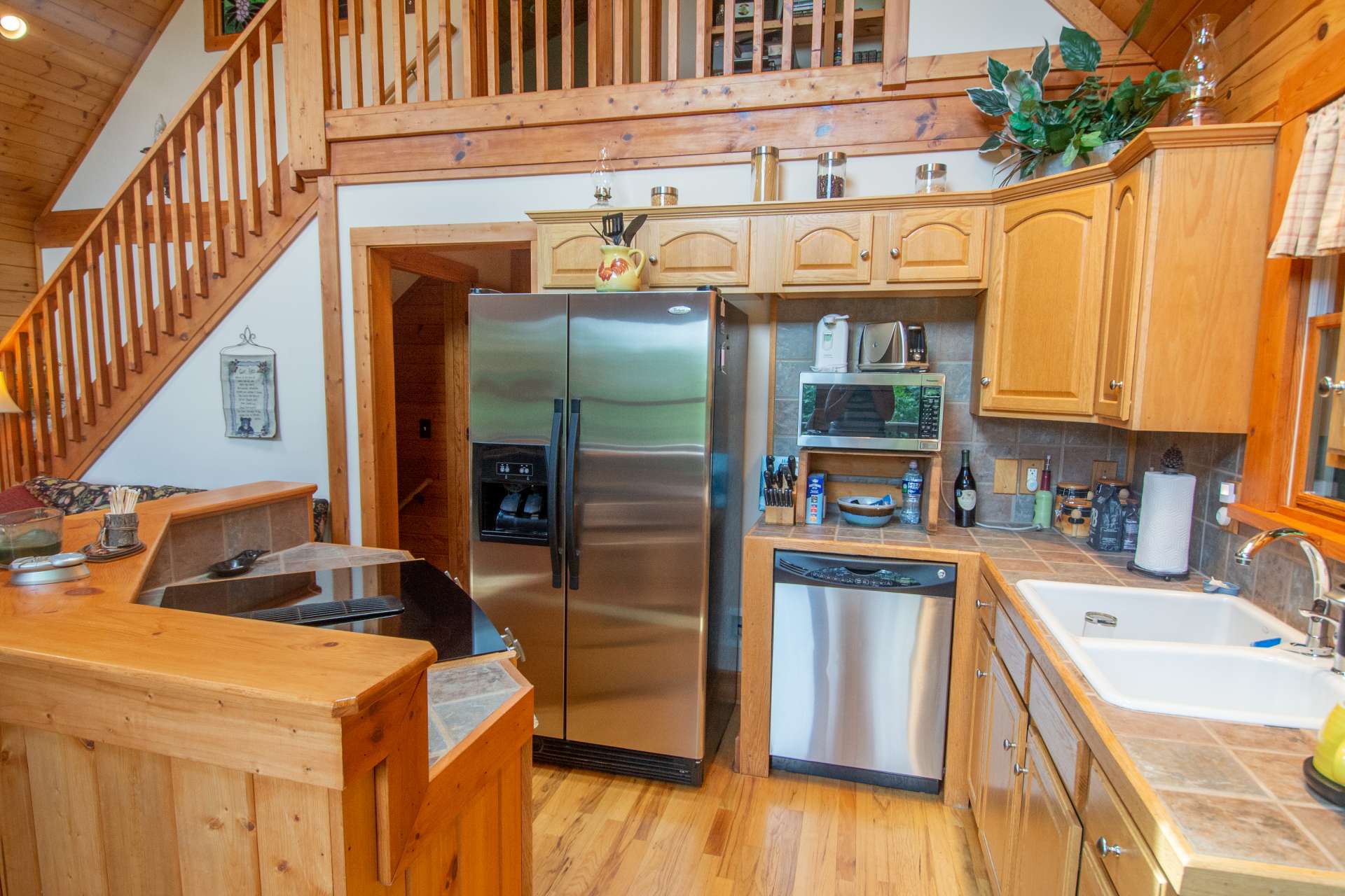 The kitchen features premium stainless steel appliances including a Jenn-Aire downdraft range built into the custom island.