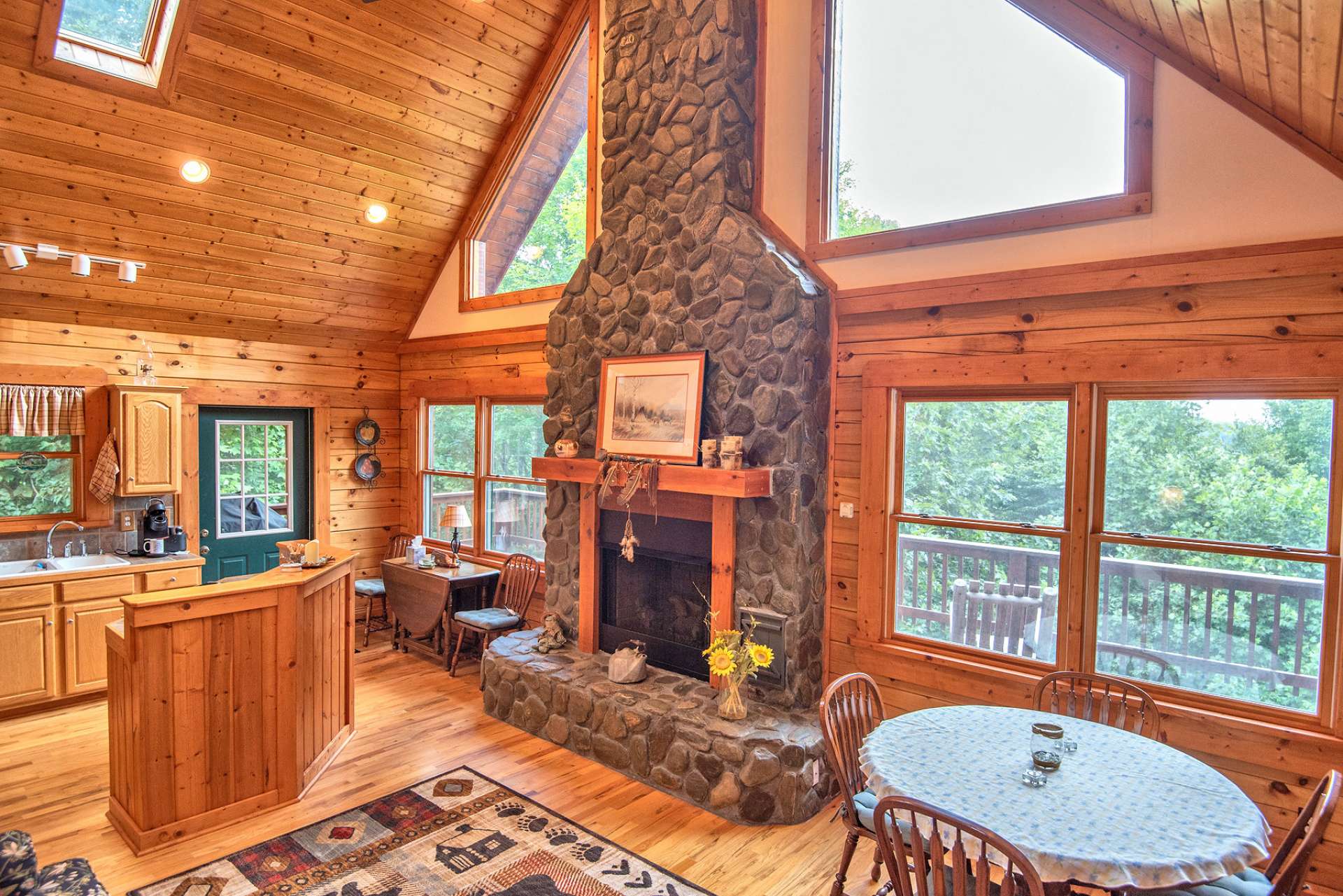 Welcoming you home, this native Ashe County river rock fireplace features easy care gas logs and a stunning heavy beamed mantle.