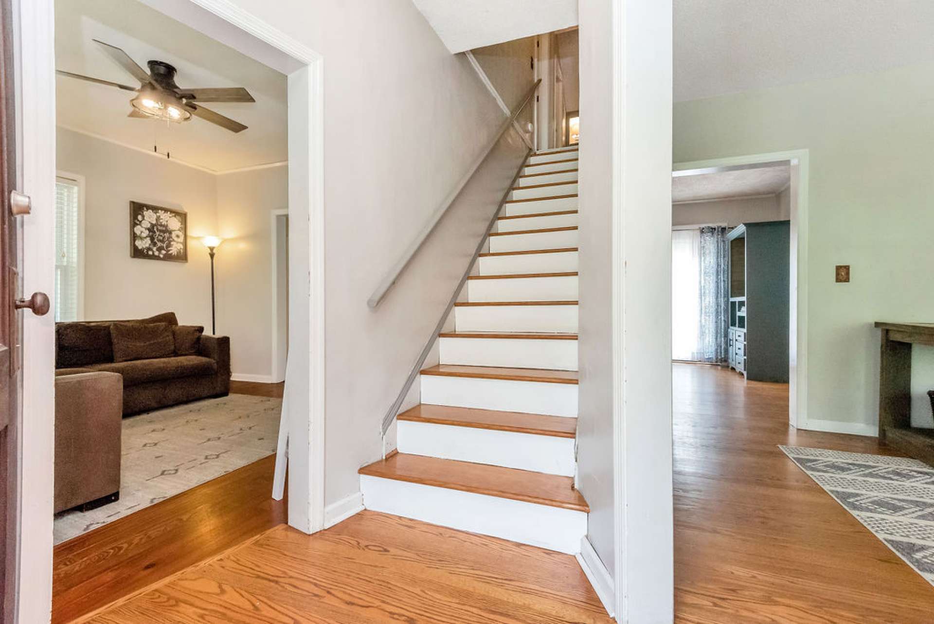 Main level entryway with living room & den on each side and stairway leading to the second level.