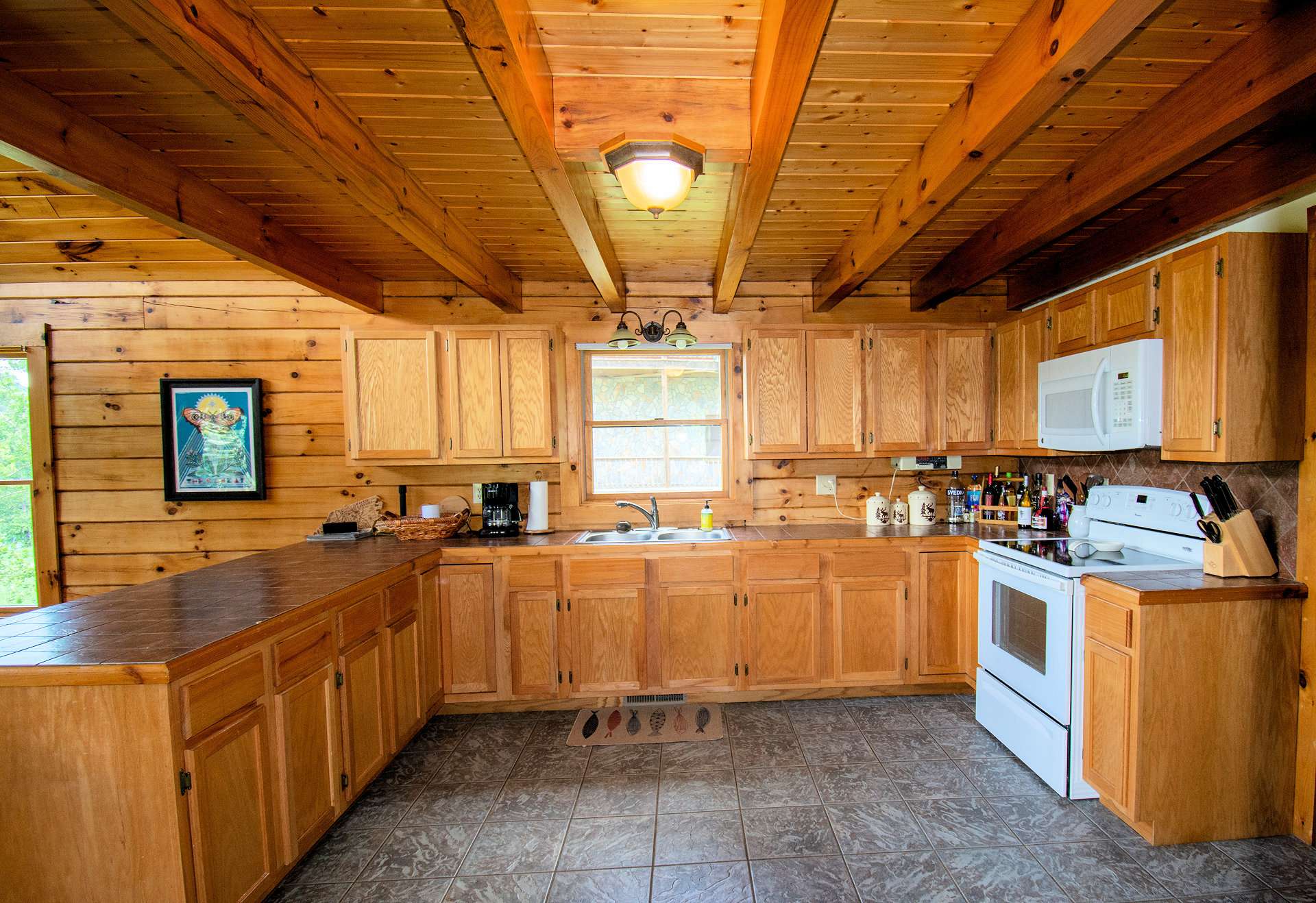 Exposed beams enhance the cabin feel. There is plenty of room for help in the kitchen.