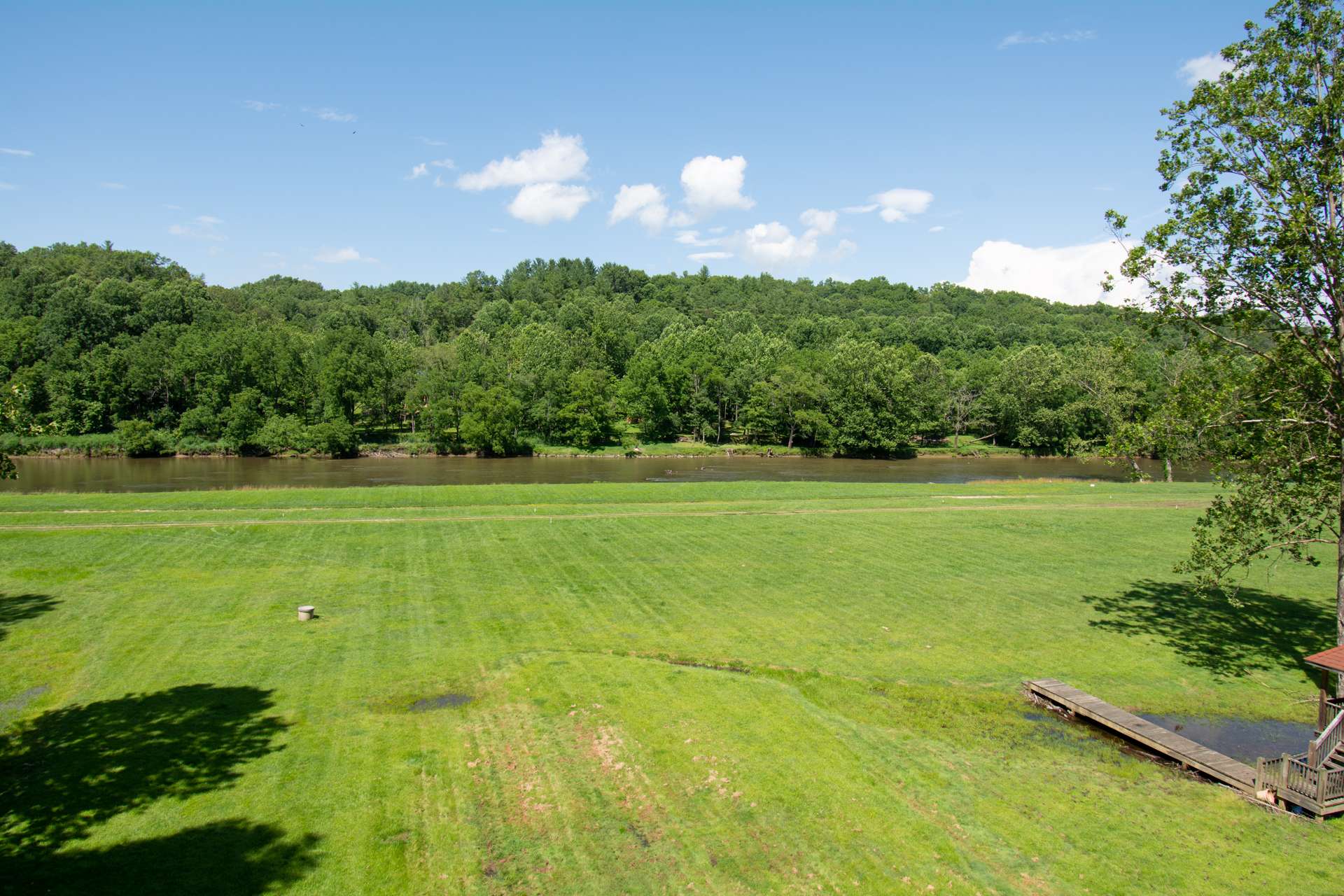 The river frontage offers an open mostly level lawn area for outdoor play and easy access to the river.