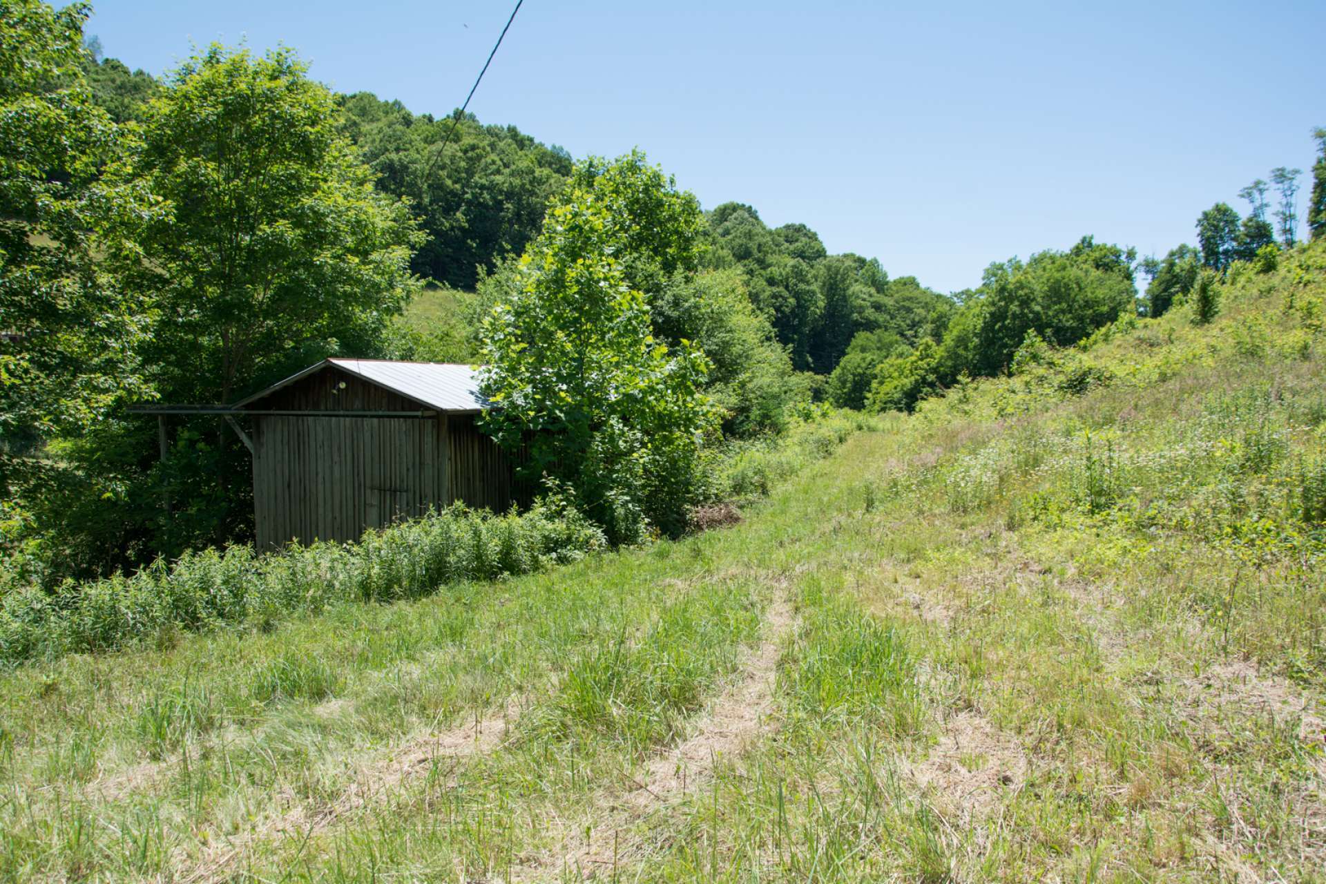 Another outbuilding provides additional space for equipment storage or barn for livestock.