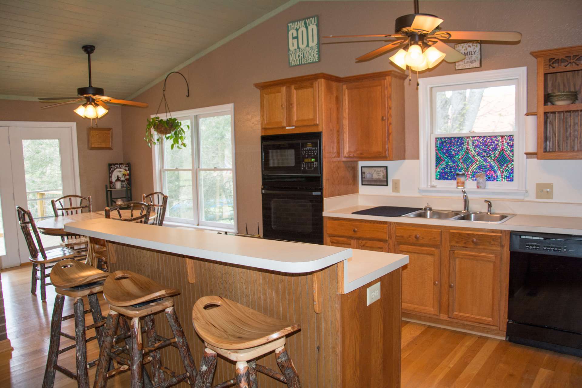 The kitchen offers plenty of work and storage  space that includes a bar with informal seating.