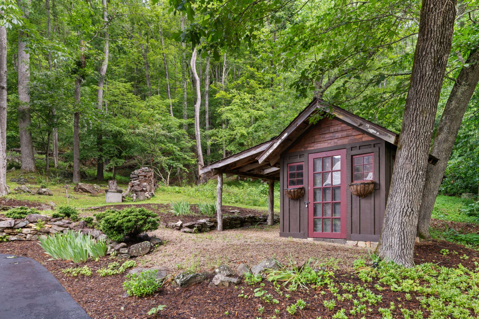 Tucked among the trees, this delightful garden shed offers a dedicated space for tools, potting, and seasonal prep.