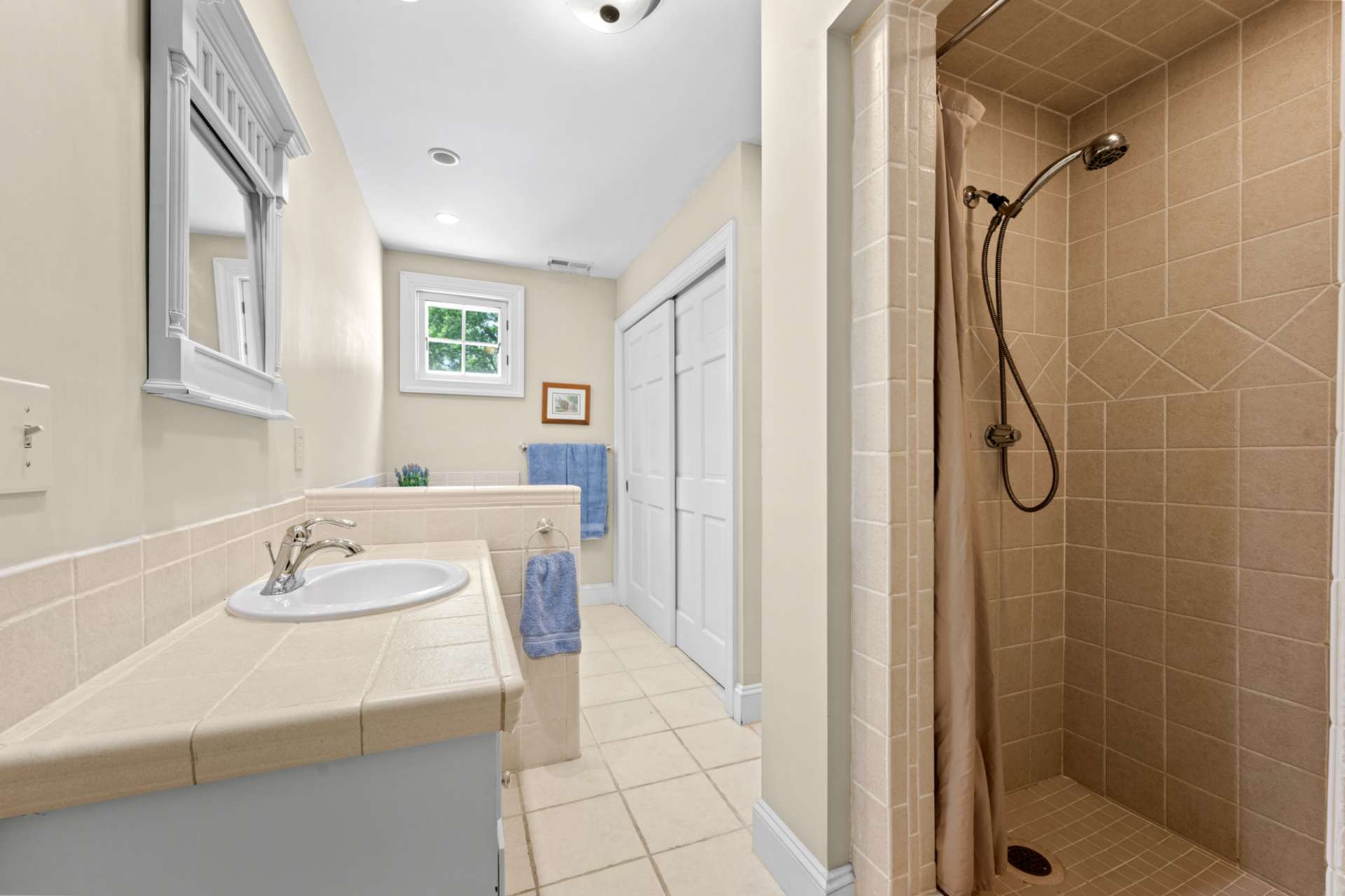 An ensuite full bath features a sleek tiled shower and timeless finishes.