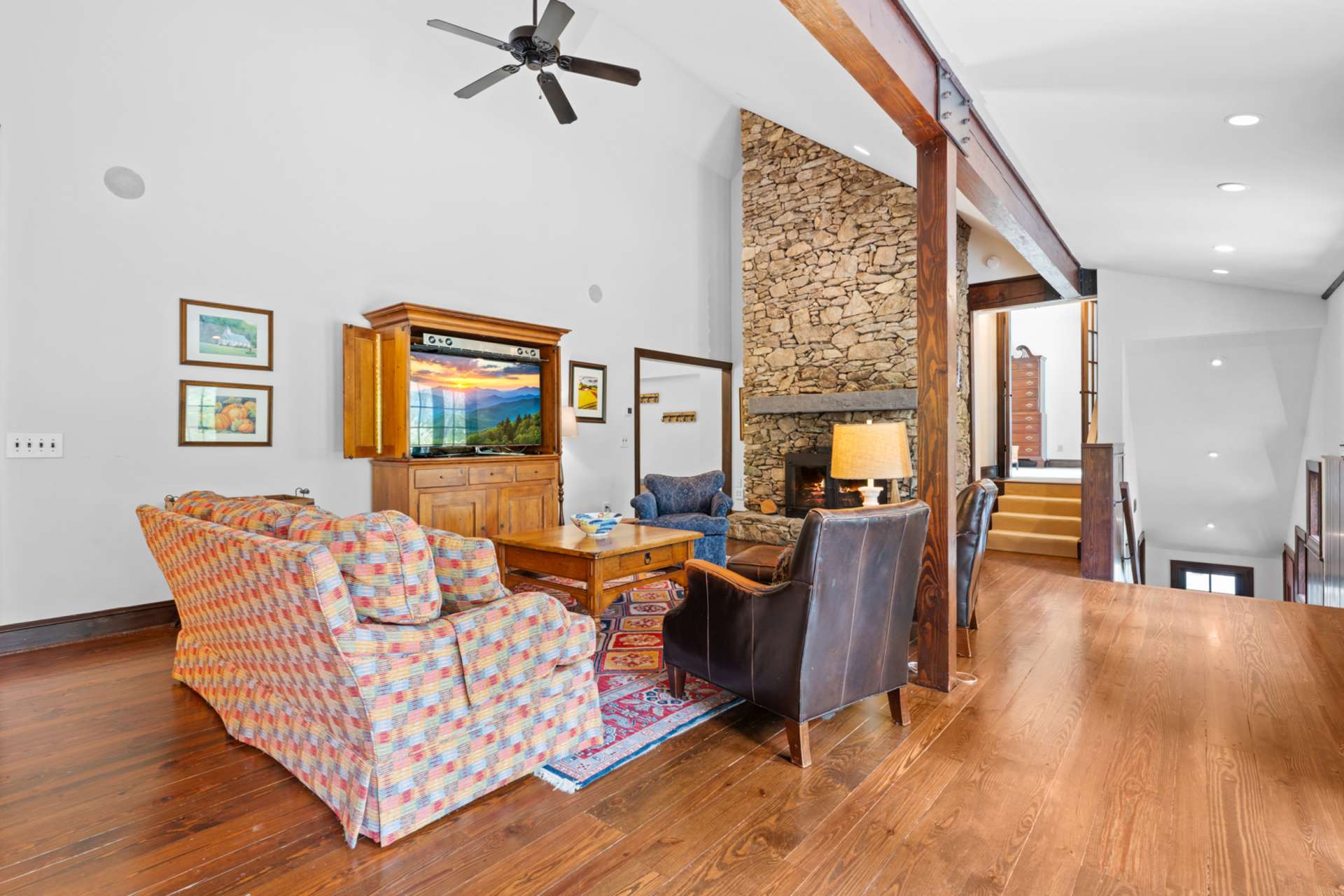 Tucked beside the fireplace, the mudroom and laundry offer everyday ease, while the elevated primary suite rests just beyond. A discreet staircase leads down to the garage and rear entry.