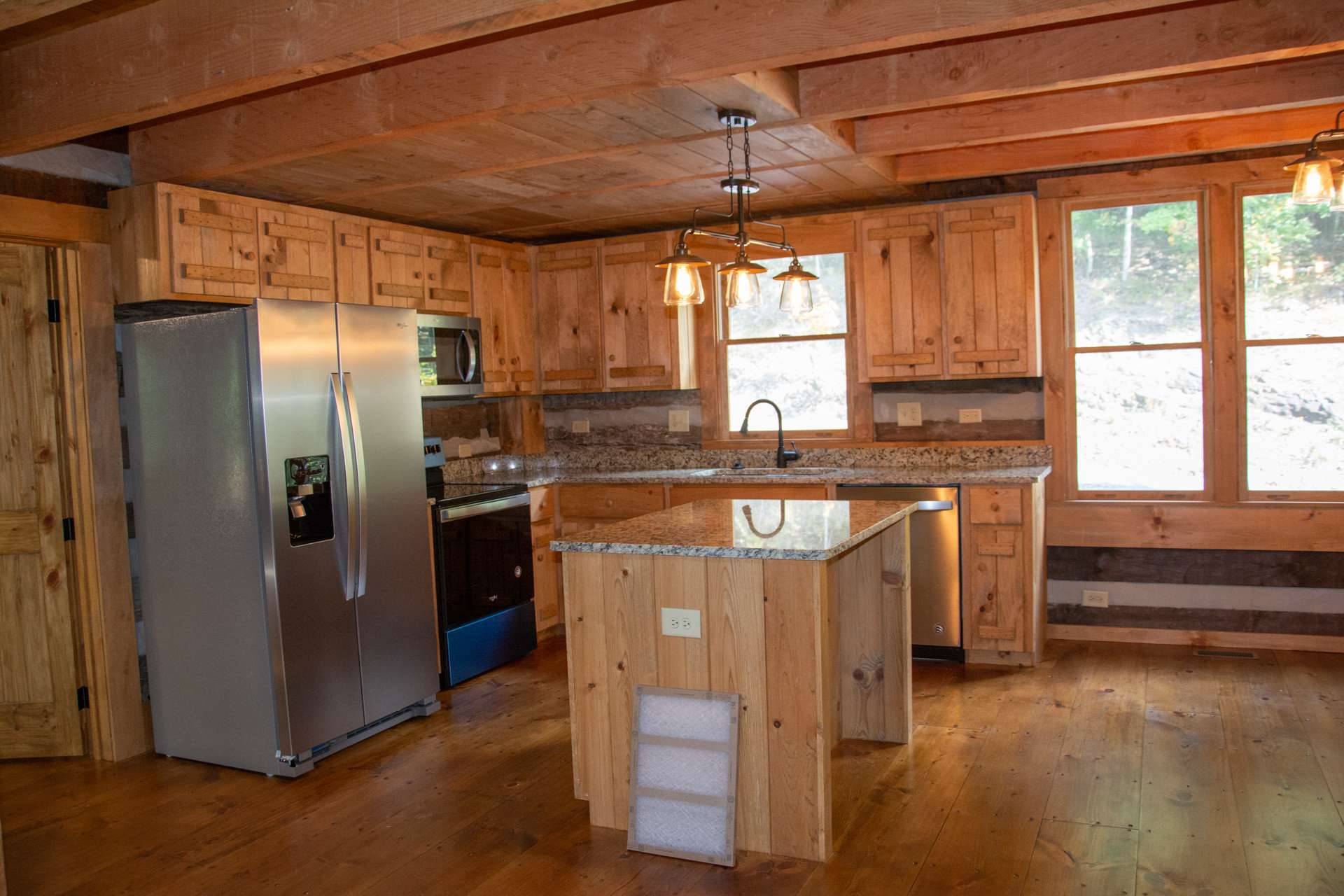 The kitchen features custom cabinetry, granite counter tops, and a center island adding to the work and storage space.