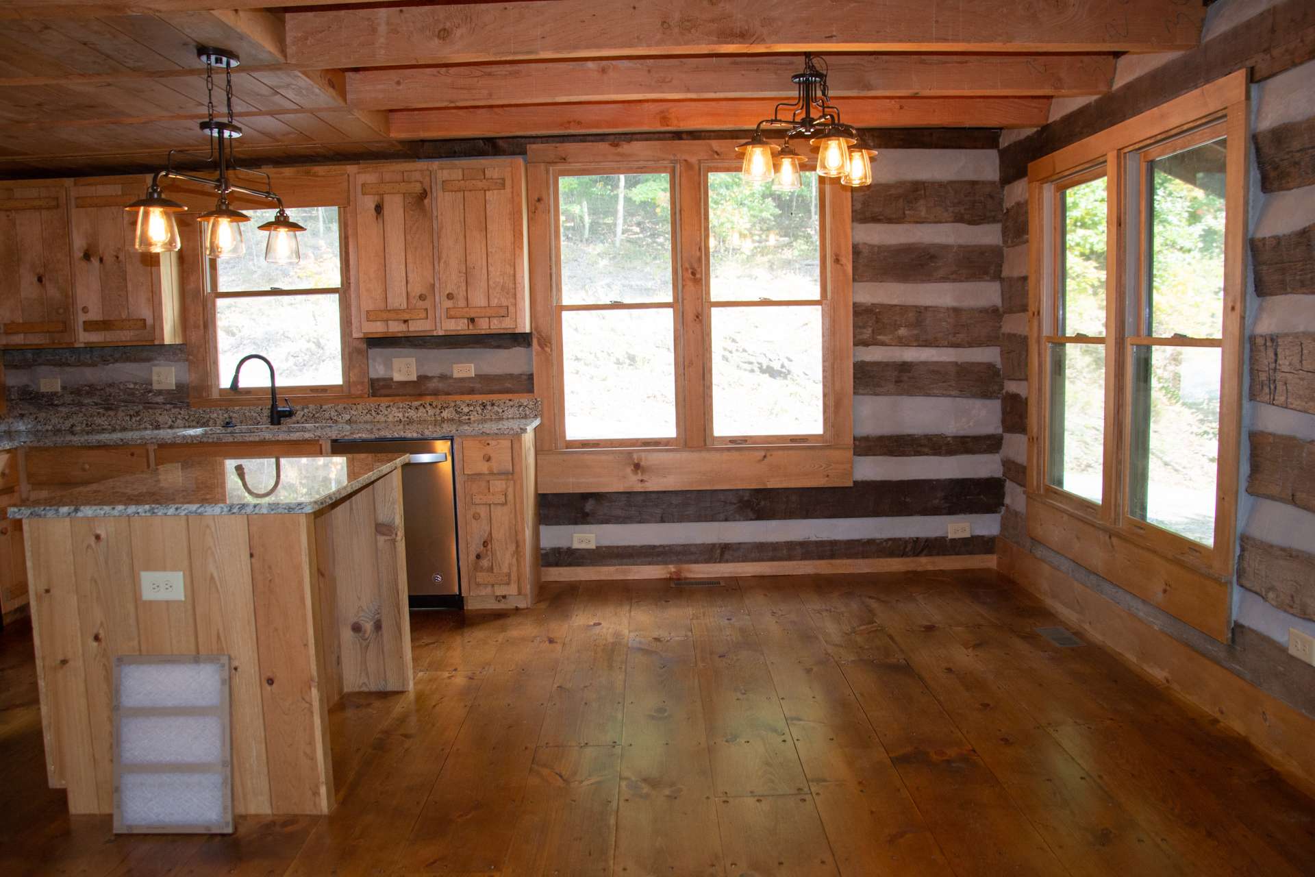 The dining area offers plenty of light and allows you to enjoy the outdoor scenery while dining inside.  This log cabin offers wide plank pine flooring throughout.