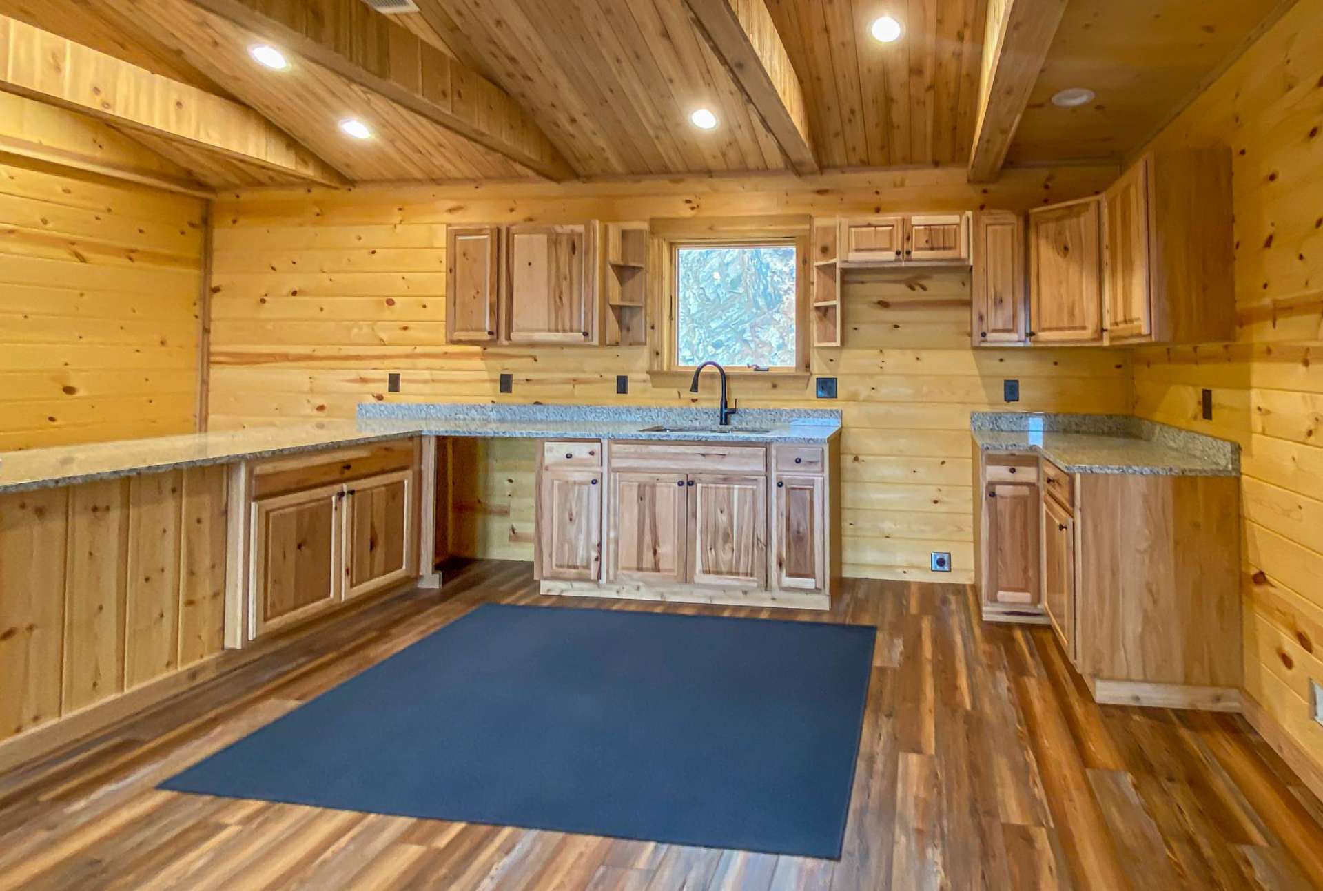 As you walk in the front door of the home the kitchen area will be on the left and the living area to your right.  The kitchen features granite countertops with custom built island that provides abundant seating and hickory cabinetry in both the main cabin and guest cabin.