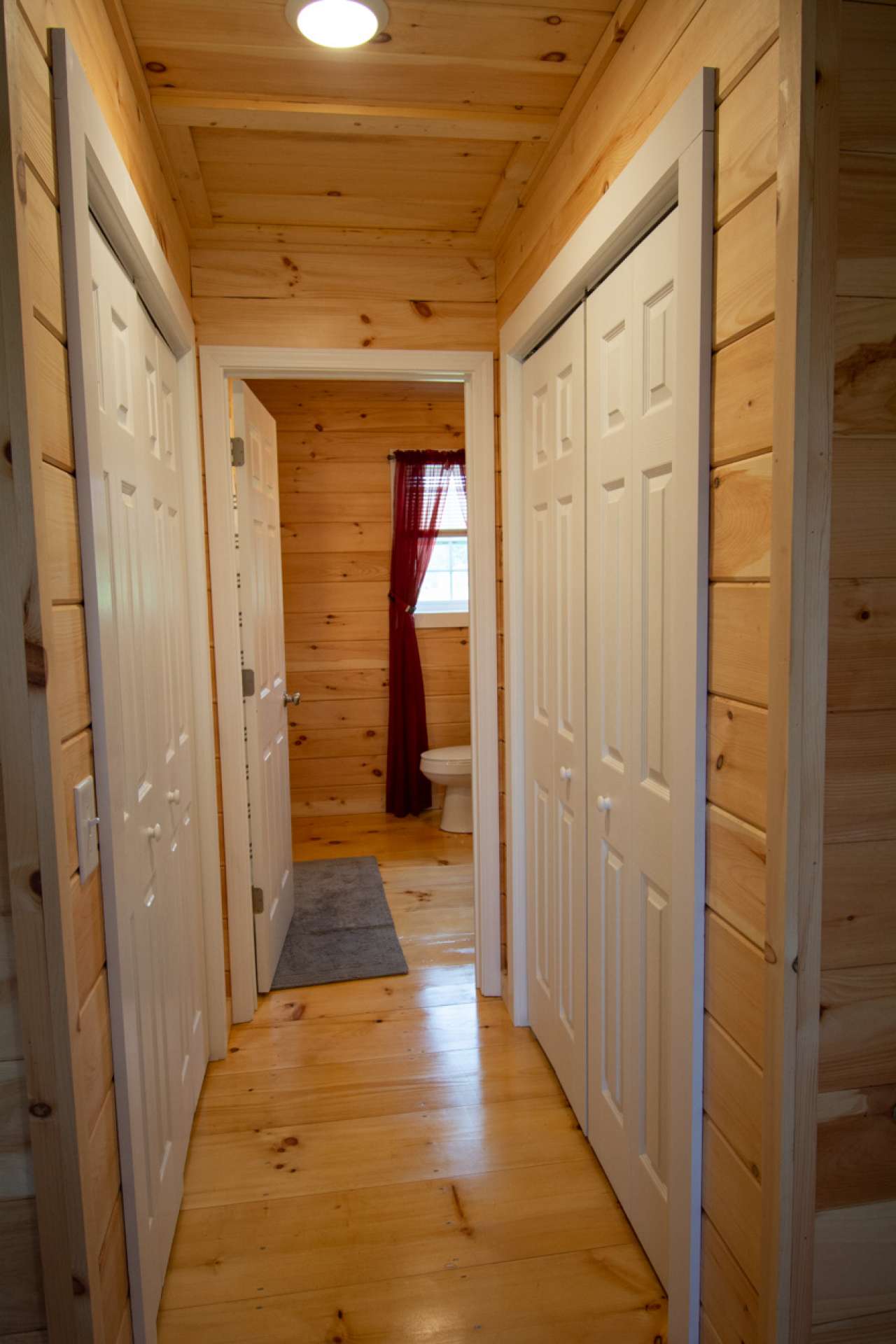 Third level hallway to bath with closets on each side.