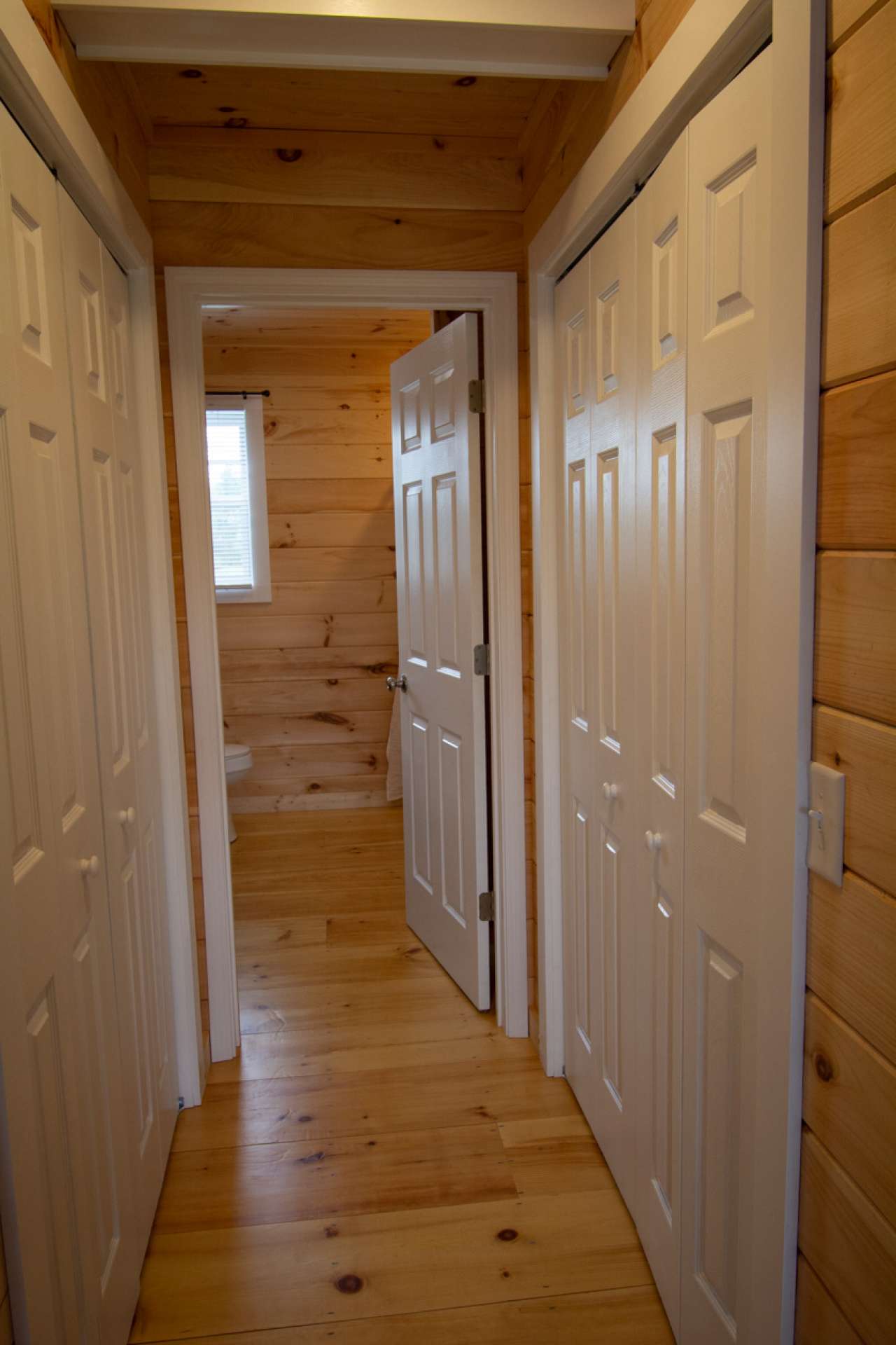 Second level hallway to bath with closets on each side.