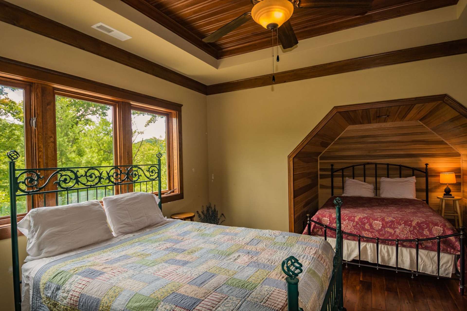 This upper level bedroom has an alcove for extra sleeping space. Notice the craftsman details in the ceilings.