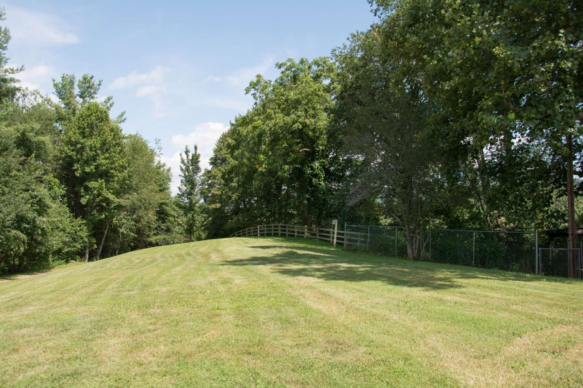 The 35+ acre setting offers lots of green space for crops, gardens, play, or livestock. Serene woodlands, with a diverse mixture of native hardwoods, evergreens and beautiful mountain foliage, offer plenty of exploration and/or hunting opportunities.