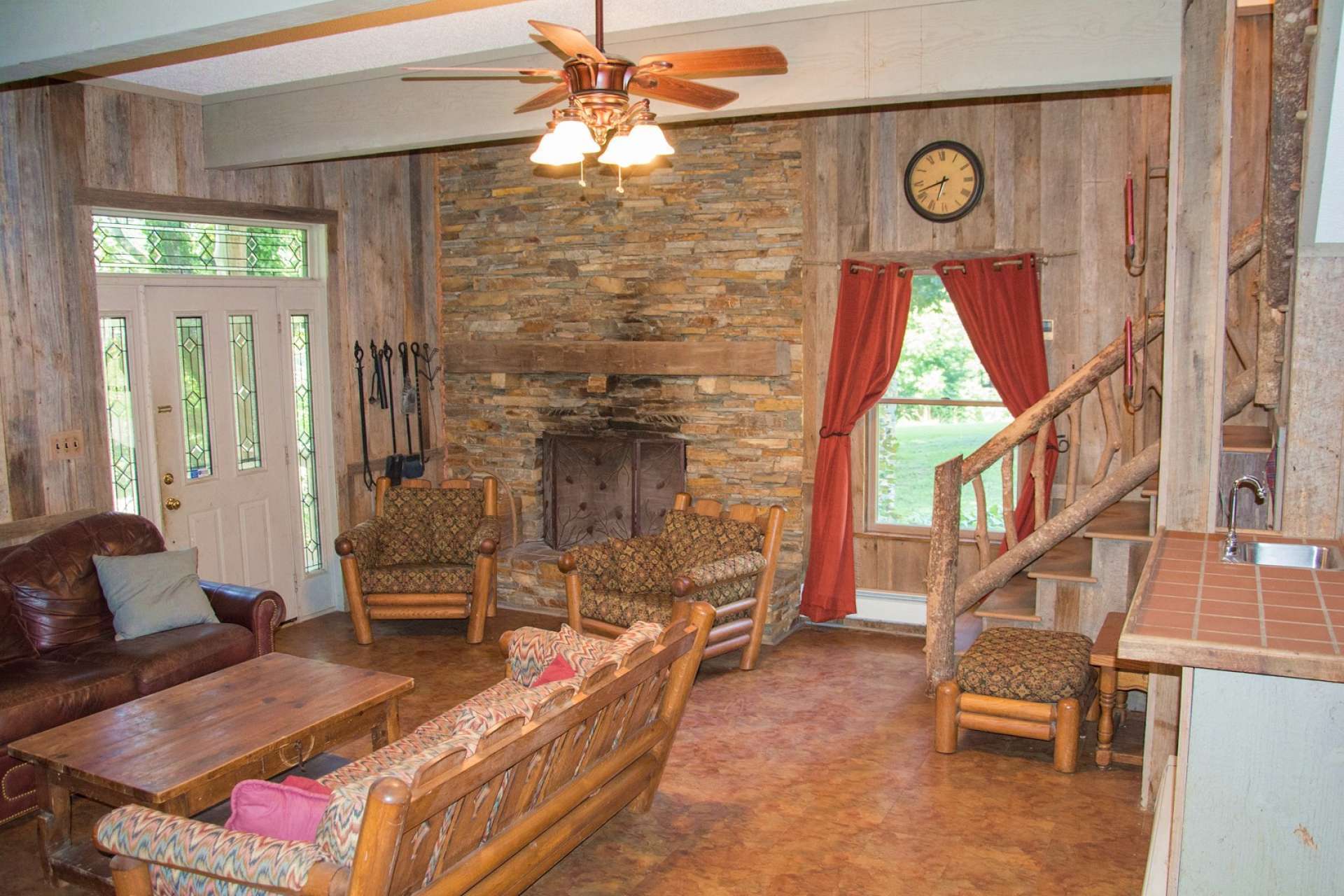 A spacious family room features barn wood accents, stone wood-burning fireplace, and a wet bar for those family gatherings.