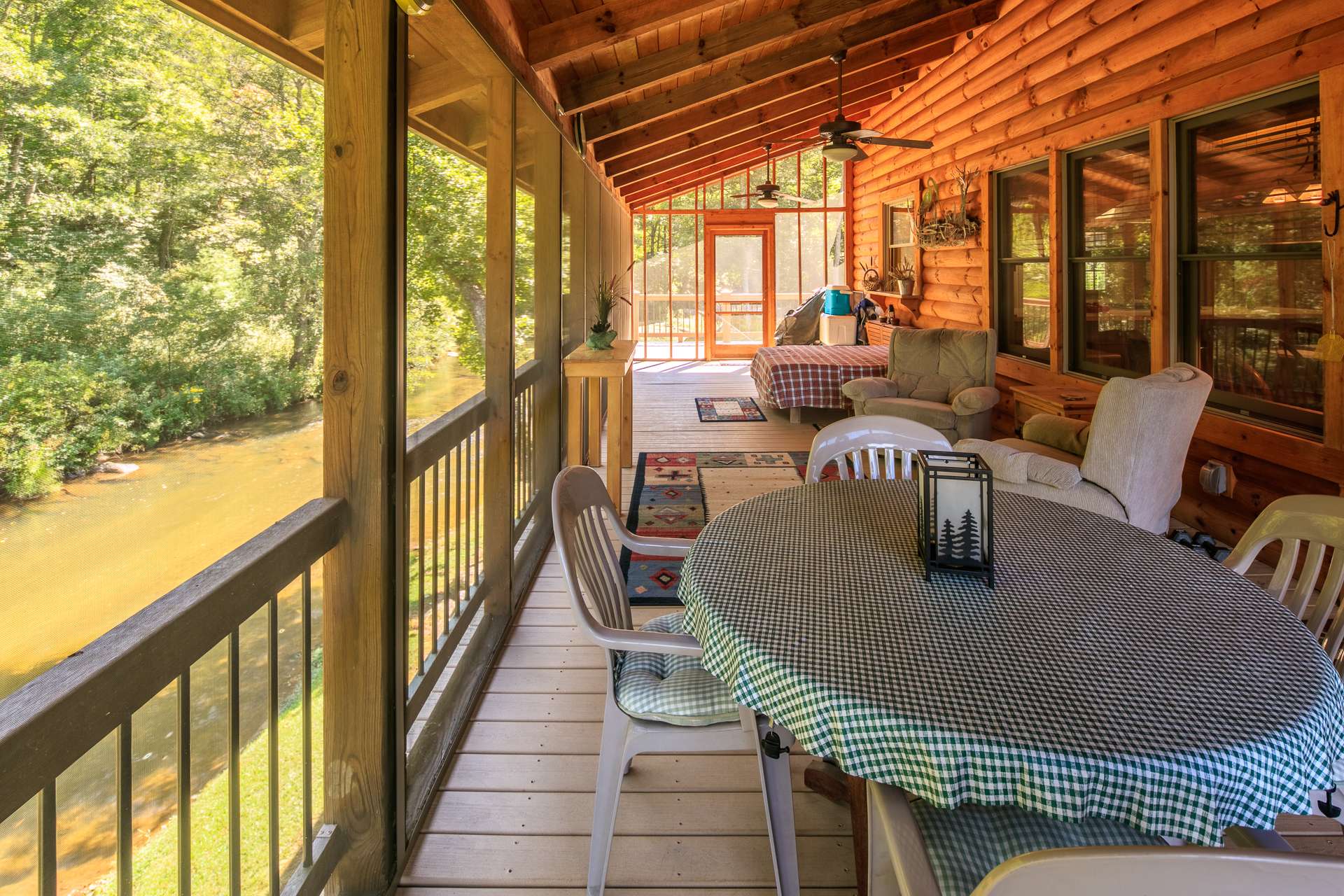 The great room also offers easy access to the back screened porch for alfresco dining above the creek.