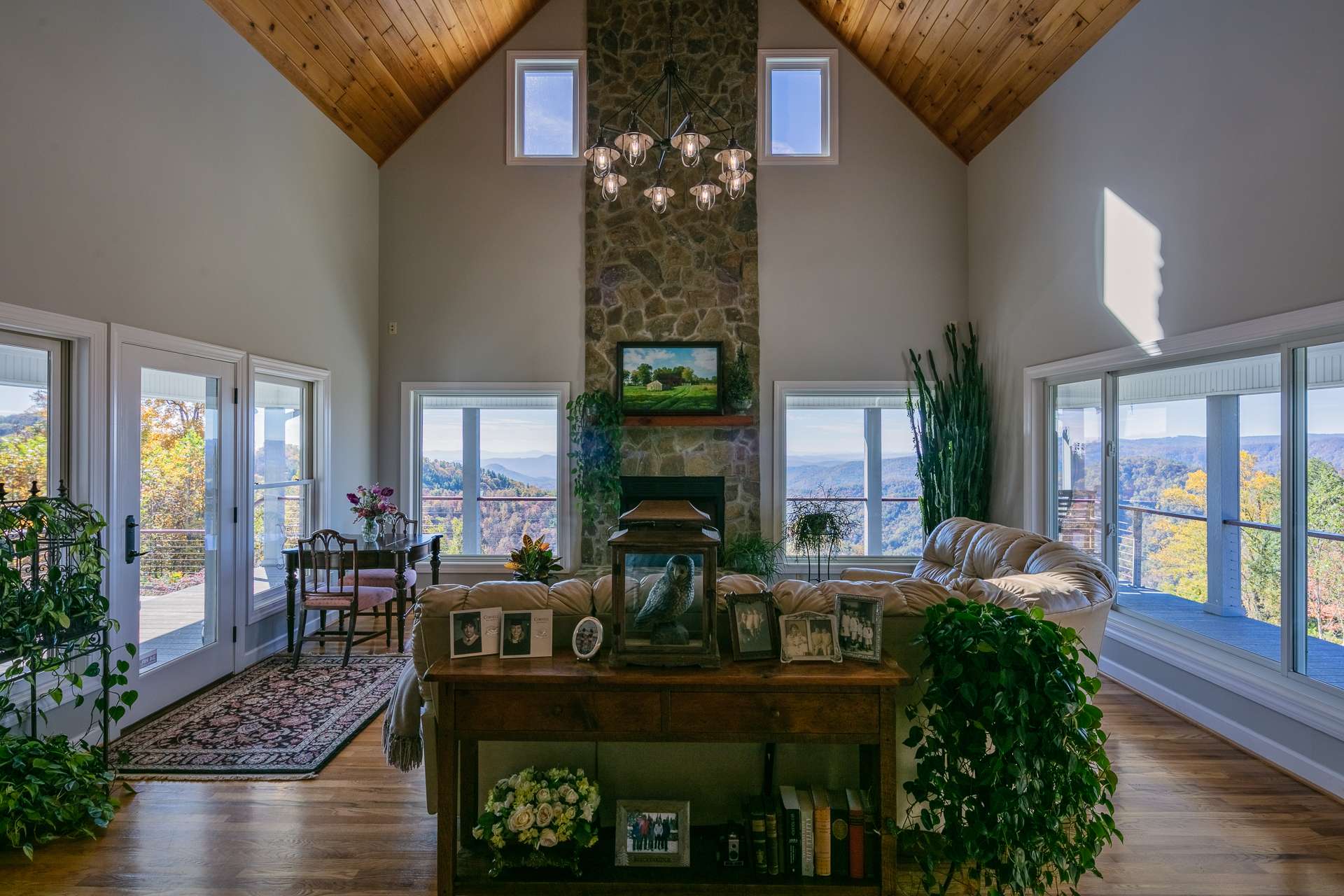 The living area features high vaulted wood ceilings, gleaming wood floors, massive floor to ceiling stone fireplace, and a wall of windows to showcase the views that include southern views into Piedmont North Carolina and western views to Grandfather Mountain, Sugar and Beech Mountains.