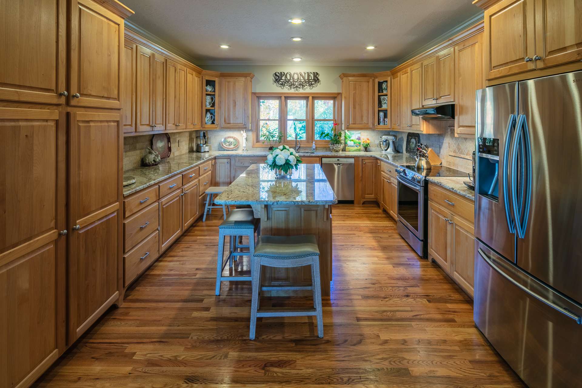 This  spacious well appointed kitchen offers custom cabinetry, granite countertops,  stainless appliances, and abundant work and storage space that includes a center island with bar seating.