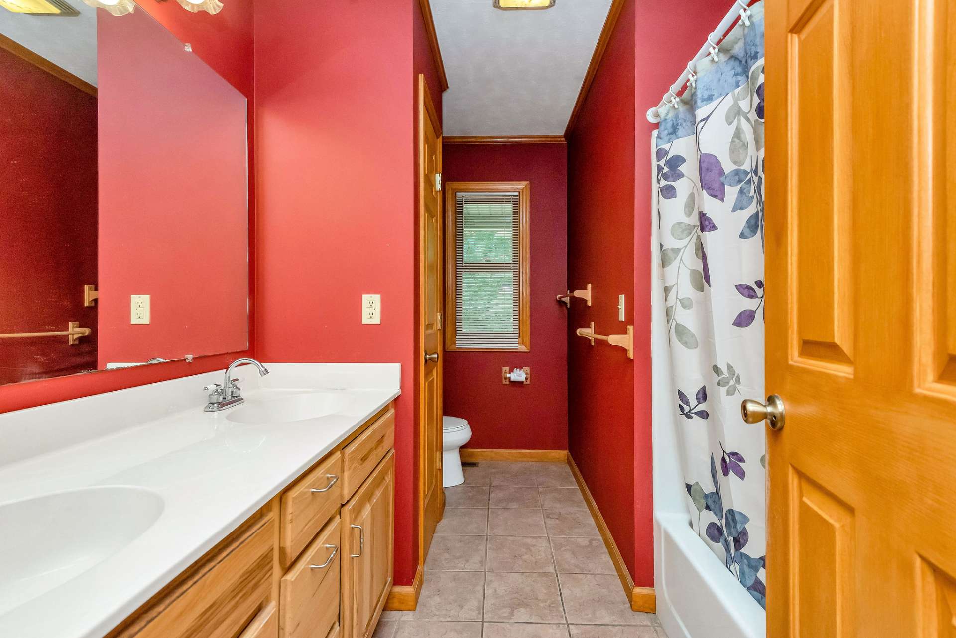 Main bath with double vanity and tub/shower combo.