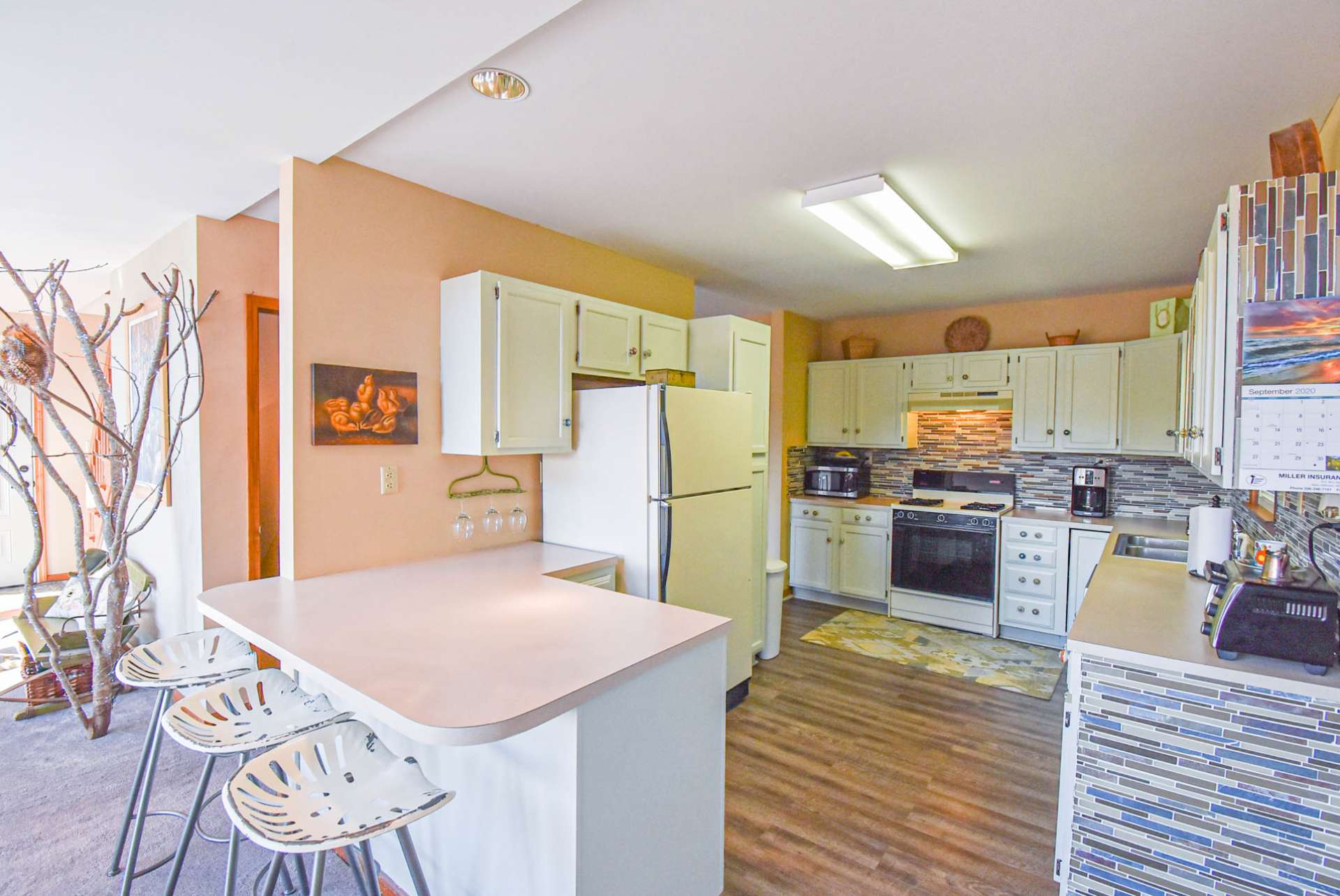 This spacious kitchen features ample work and storage space including a bar with seating.