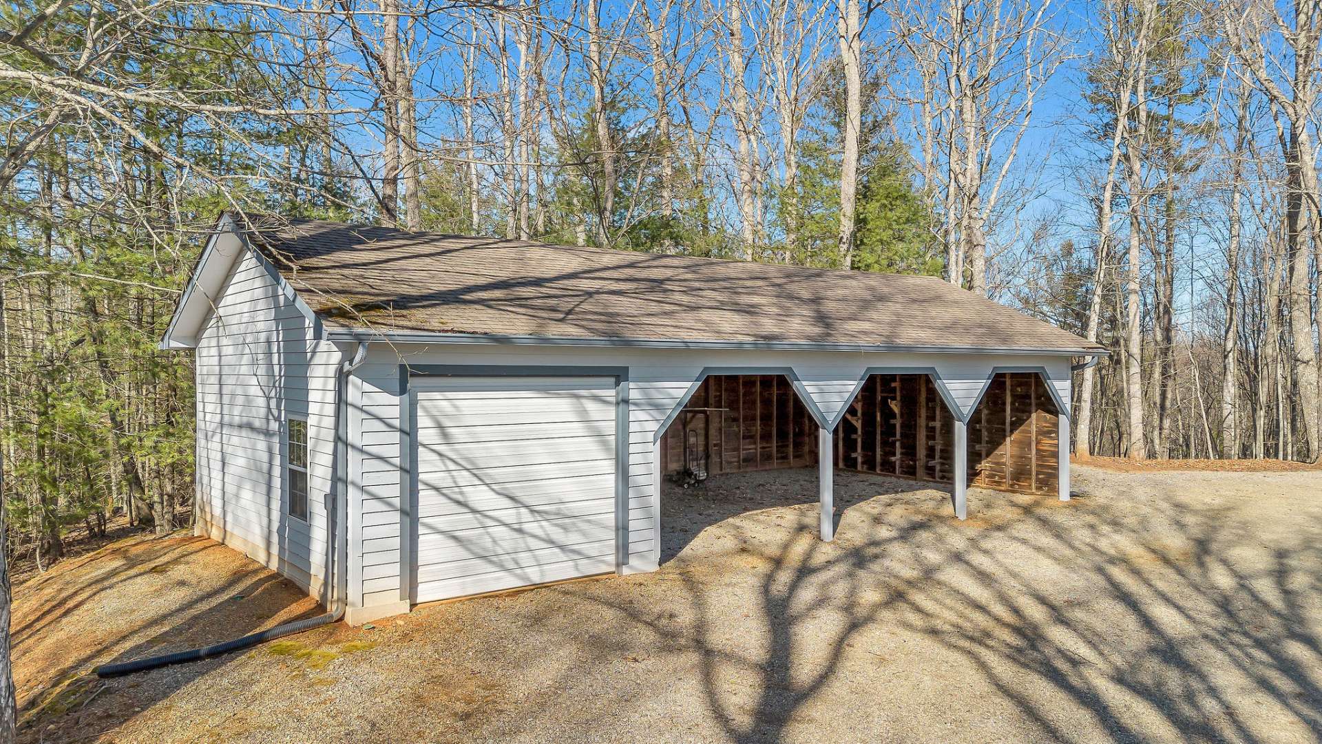 A versatile four-bay outbuilding suited for equipment or vehicle storage.