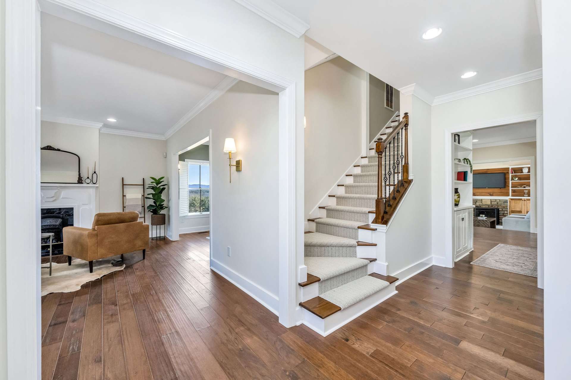 The staircase has an updated railing, new lighting, and a carpet runner.
