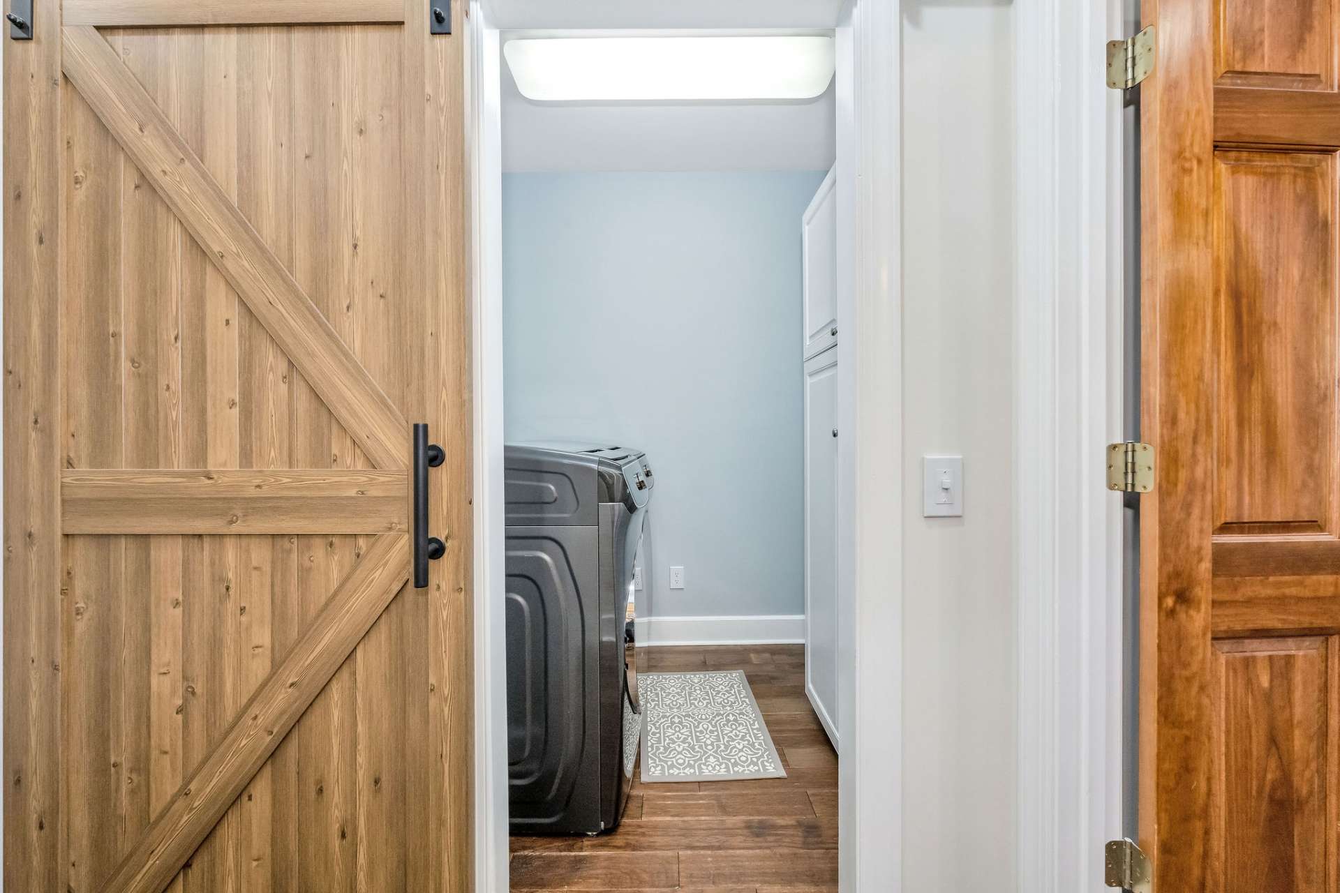 This main level laundry room with storage is outside of the primary bedroom and across from the guest half bath.