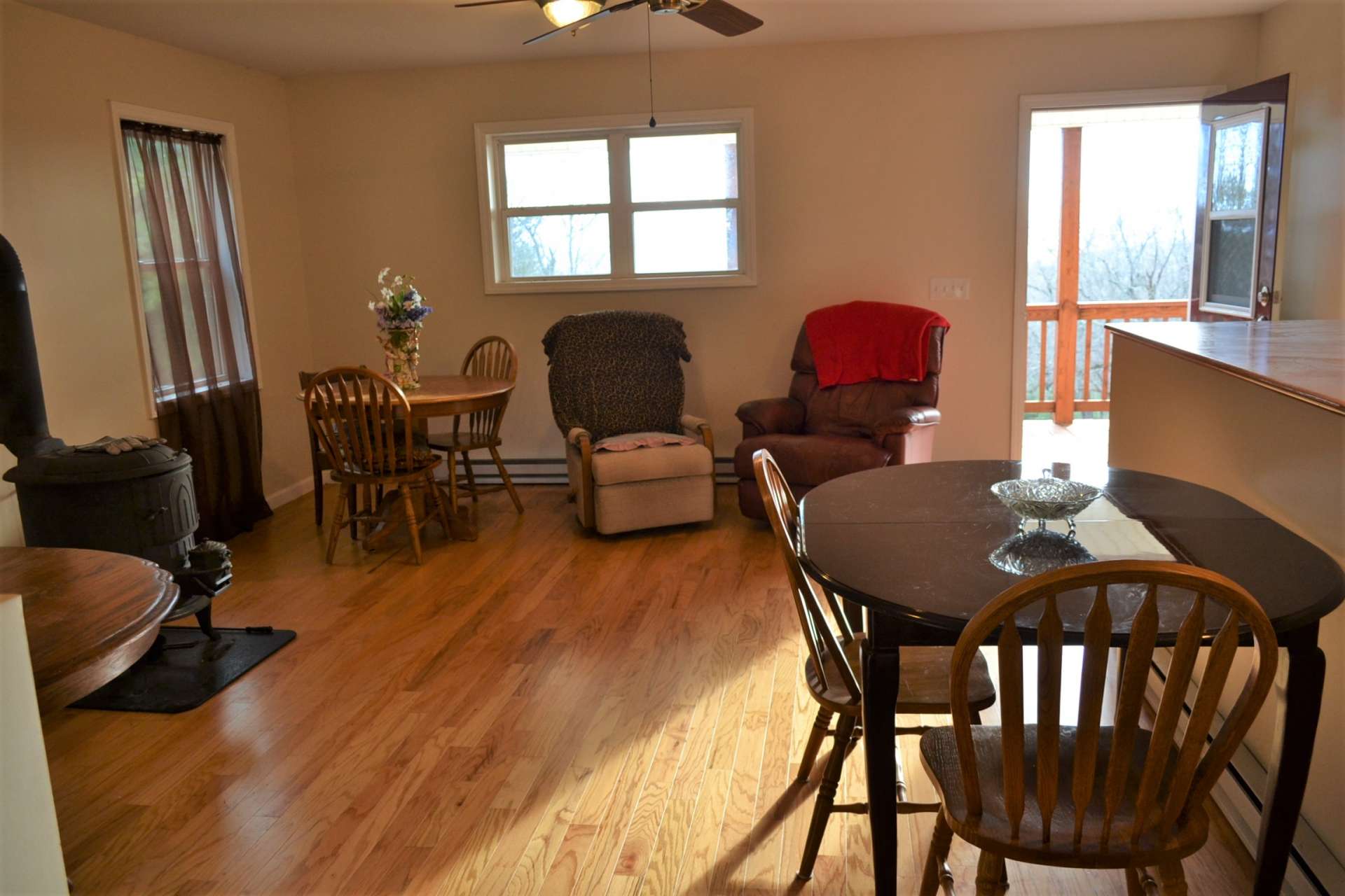 This sweet cottage features an open floor plan with the kitchen, dining, and living areas open to each other. The wood floors and wood burning stove adds warmth to the area and keeps the cottage cozy during cool winter evenings.