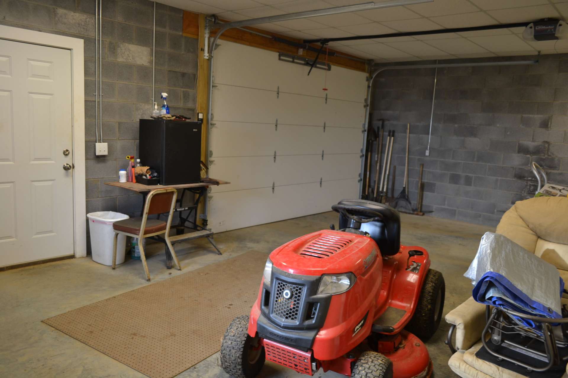 The full walkout lower level offers expansion potential on one side, and a workshop/garage area on the other side.  The garage/workshop area is plenty large enough for your vehicle and your lawn and garden equipment.