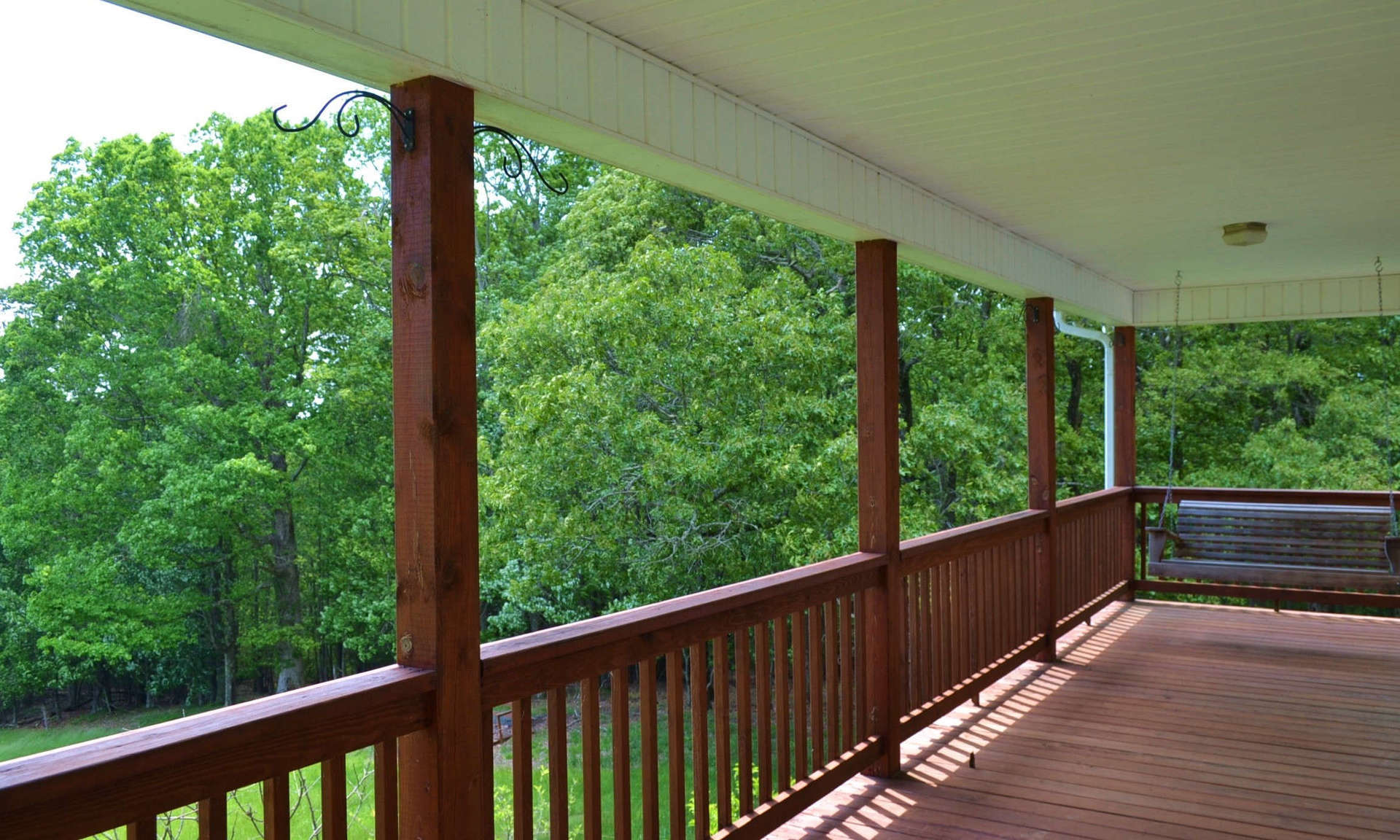 A full length covered deck is the ideal space to enjoy a tall glass of iced tea while enjoying the views, mountain scenery, and the sounds of Nature.