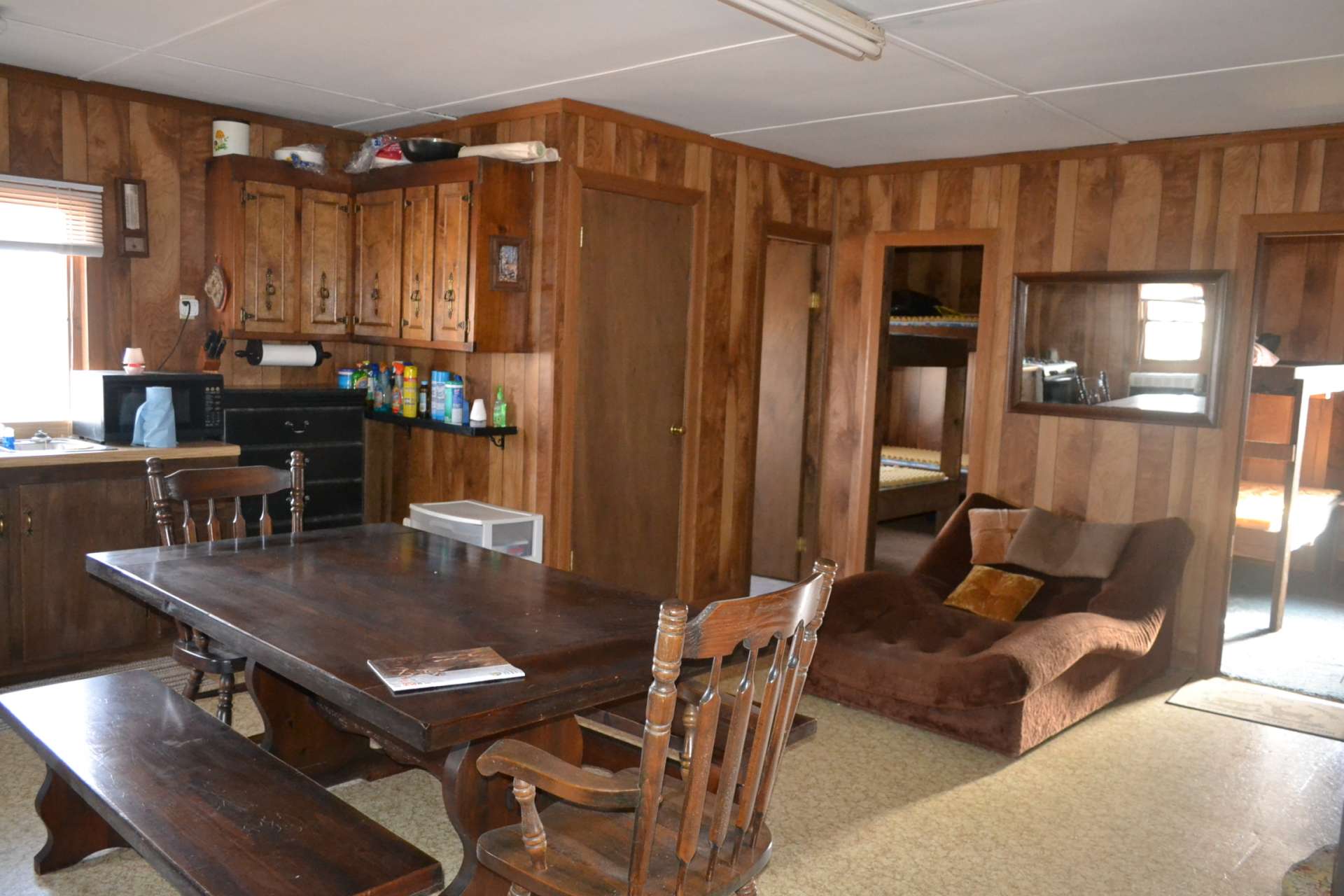 An open great room includes the living, kitchen and dining area with wood stove and propane heater.