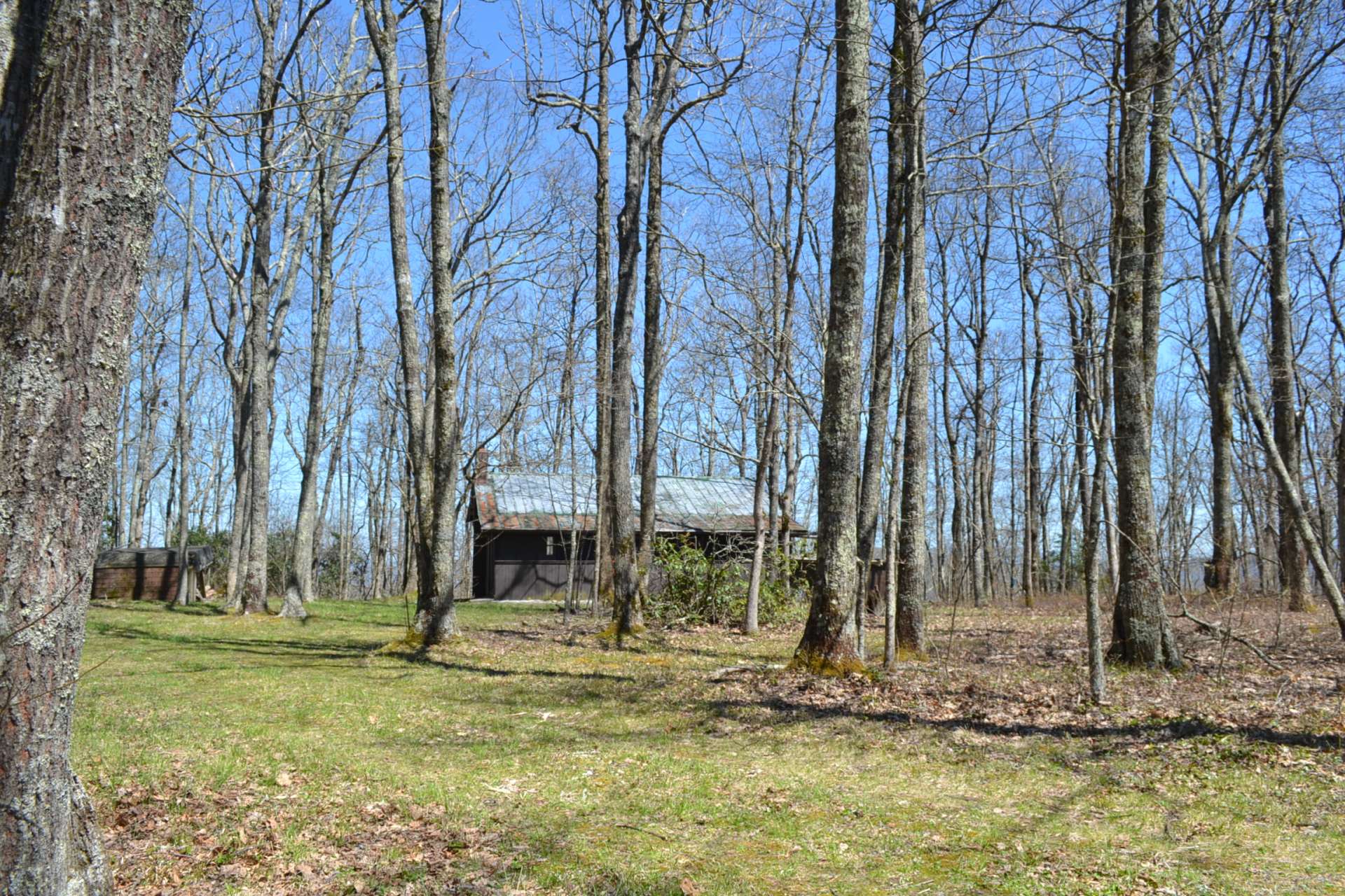 The property offers a small off the grid hunting cabin with  a covered porch to access the main living area.