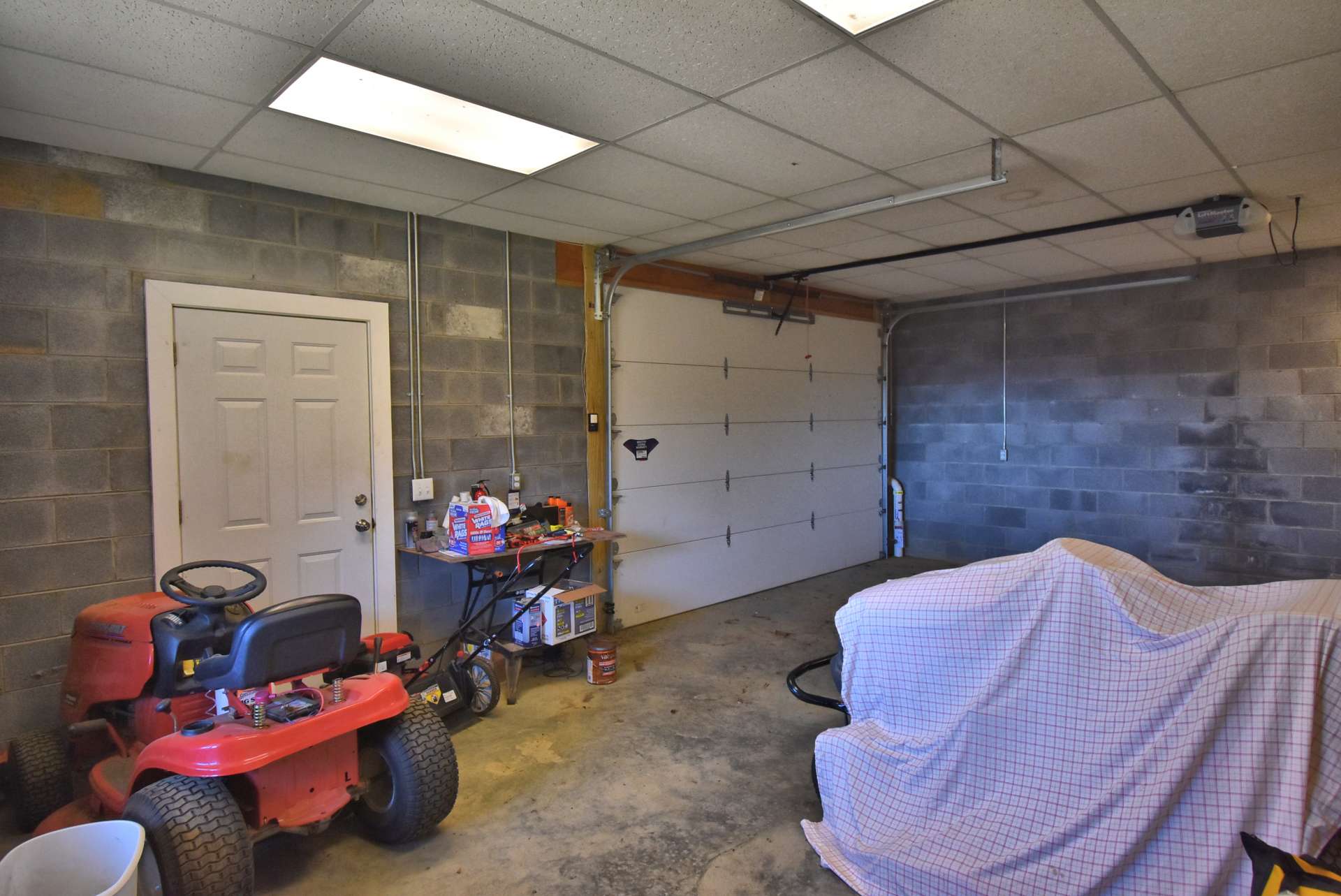 The full walkout lower level offers expansion potential on one side, and a workshop/garage area on the other side.  The garage/workshop area is plenty large enough for your vehicle and your lawn and garden equipment.