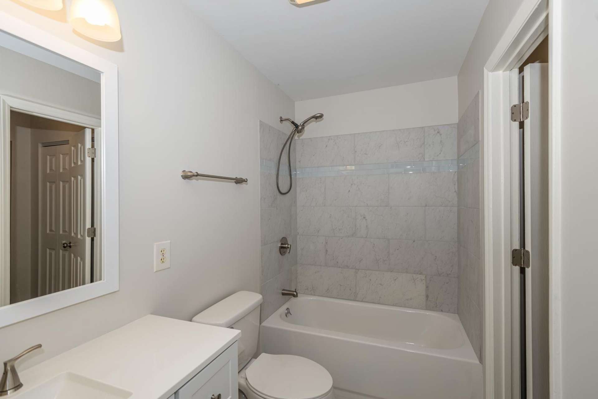 The newly updated bath features new tiled floor and tub surround, as well as new fixtures.