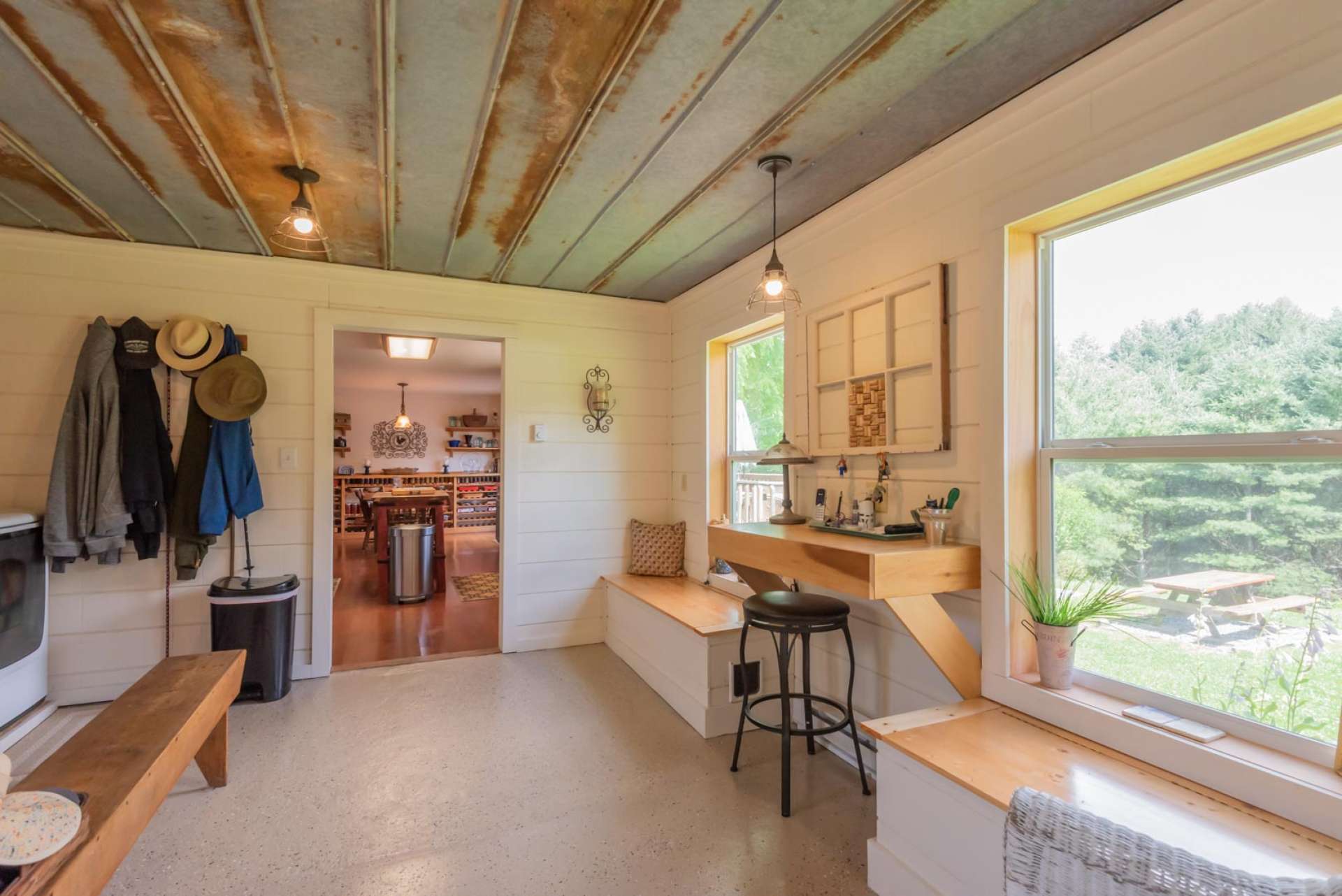 View of the mud room/laundry room entering from the garage. Room features a large utility sink, built in storage benches as well as a built in desk.