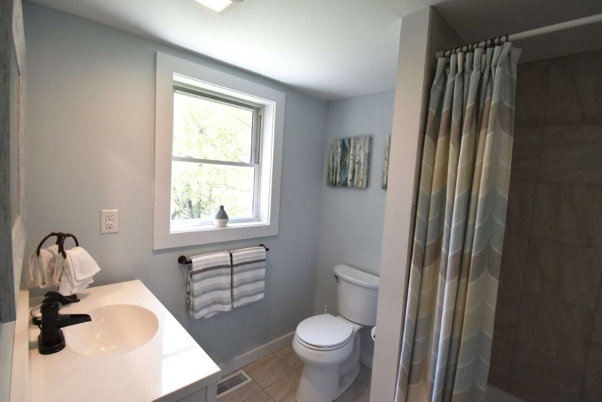The bathroom is also charming with ceramic tile floor that extends into the tub/shower area.
