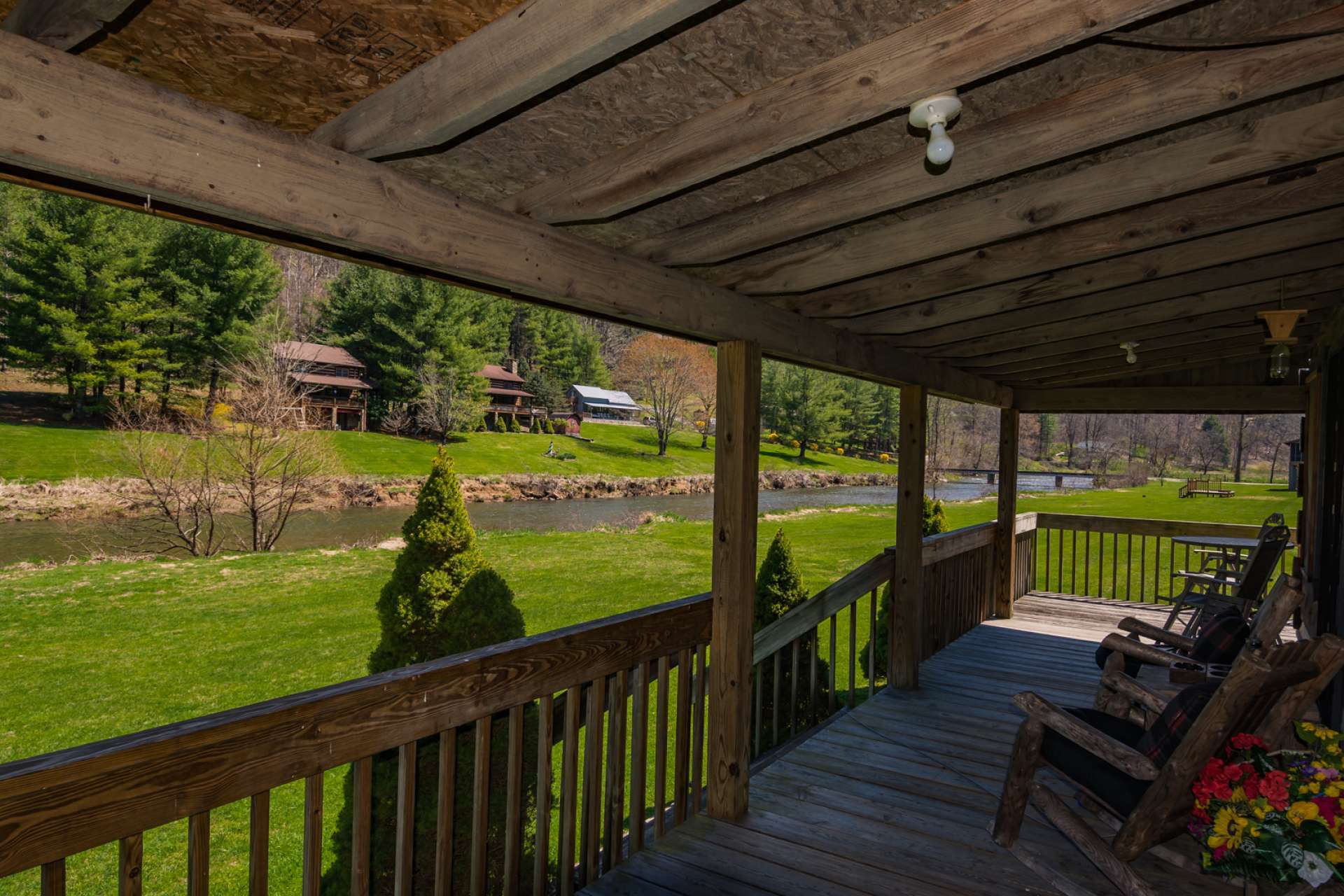 Relax on the covered porch and watch the North Fork of  the New River as it flows by the property.