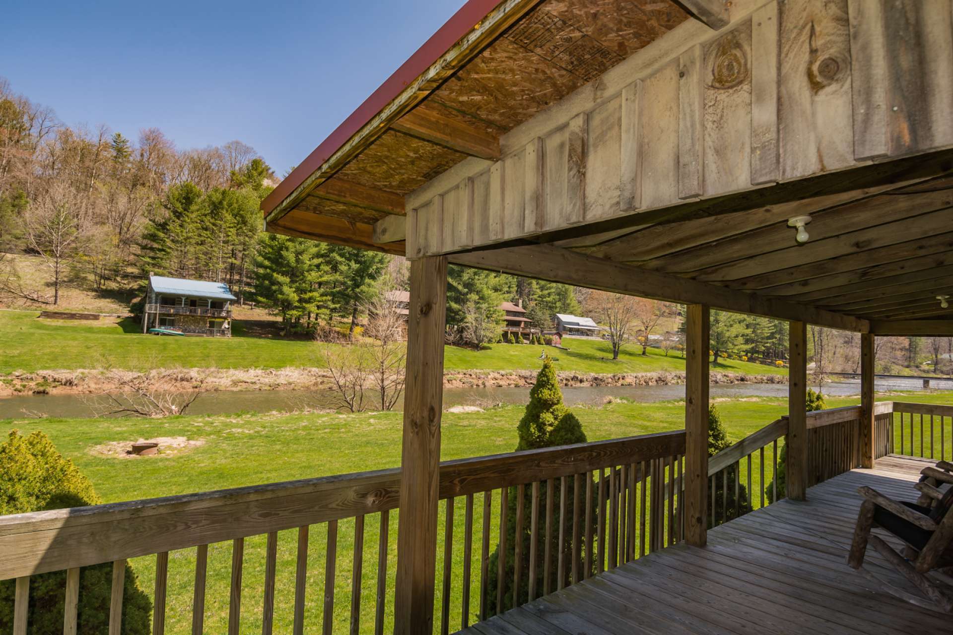 The spacious covered porch extends the living space outside and enjoys the amazing frontage on the New River, just steps away.