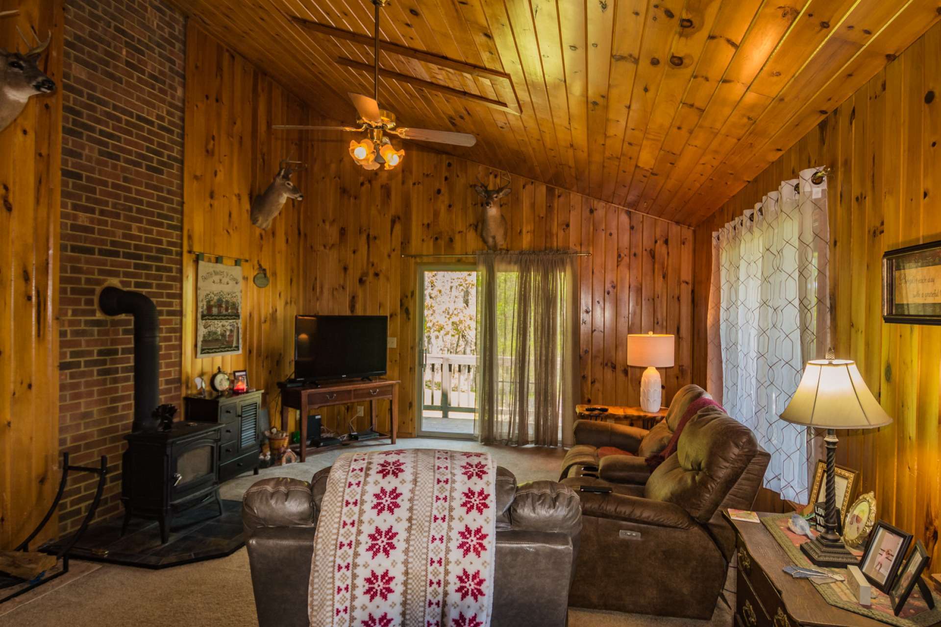 The open floor plan includes this vaulted living area with  access to the covered deck.