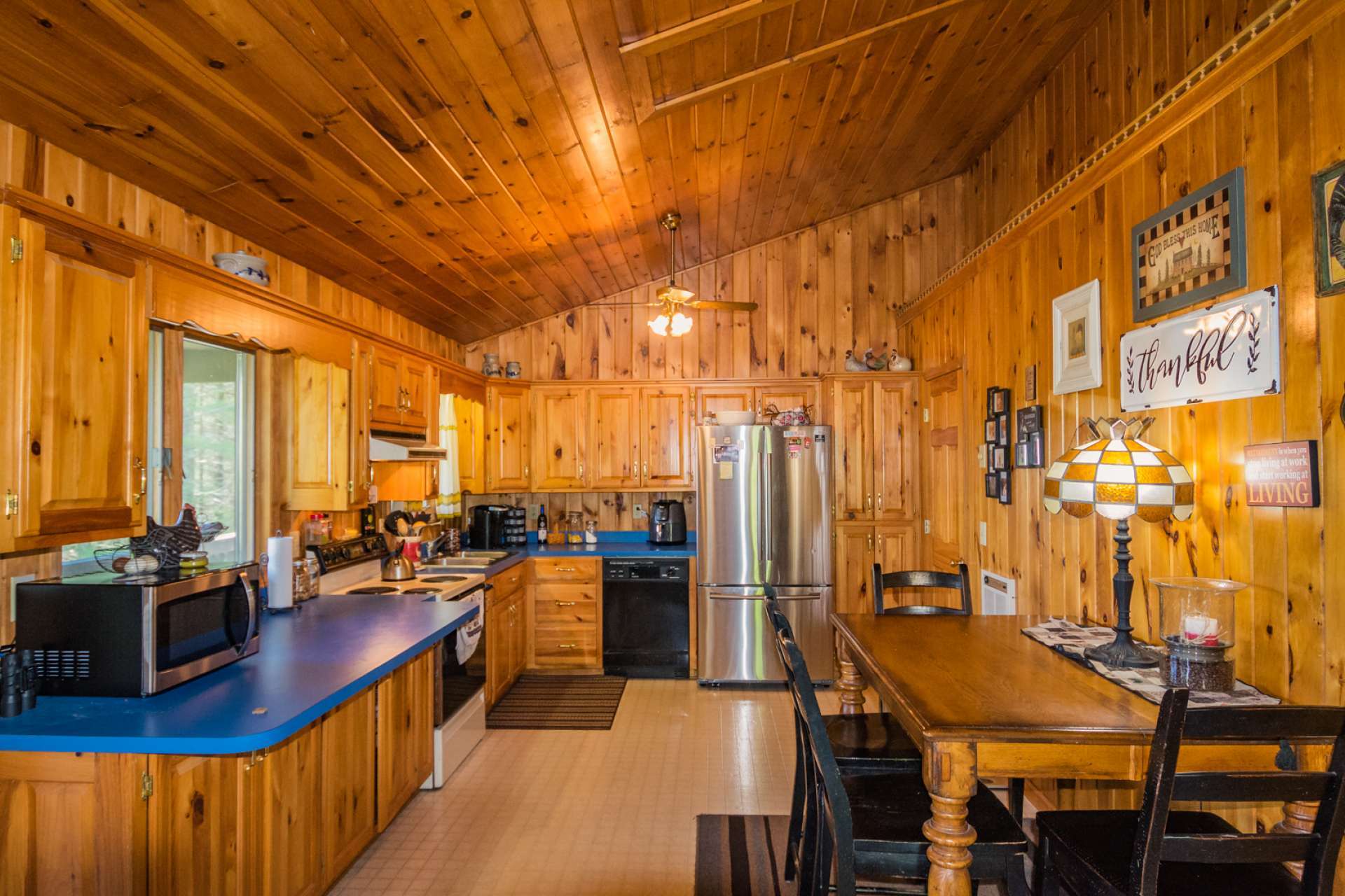 The bright and airy kitchen and dining area  offers lots of cabinets for storage and work space.