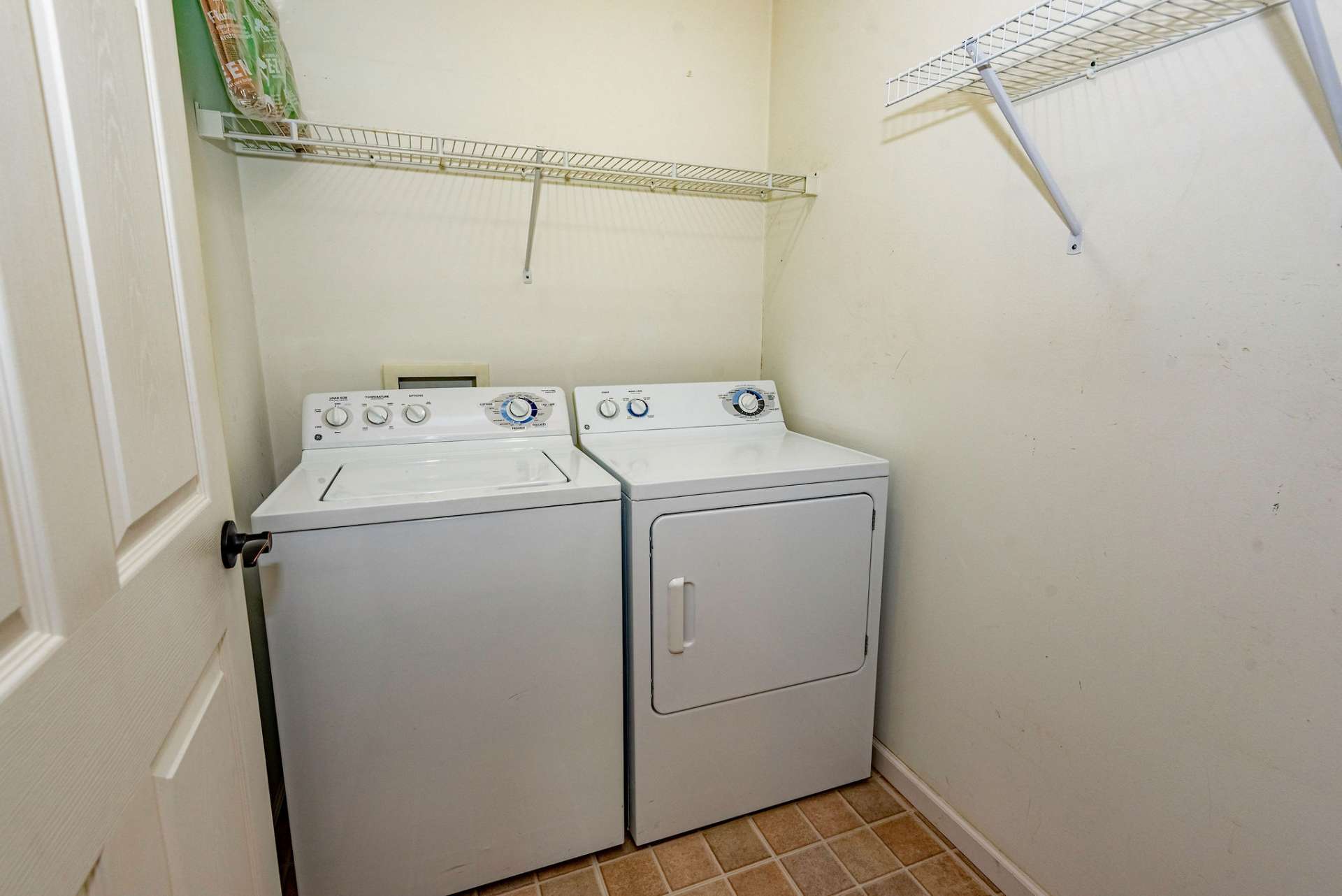 Spacious laundry off of the kitchen/dining room with racks already installed for hanging your clothes.