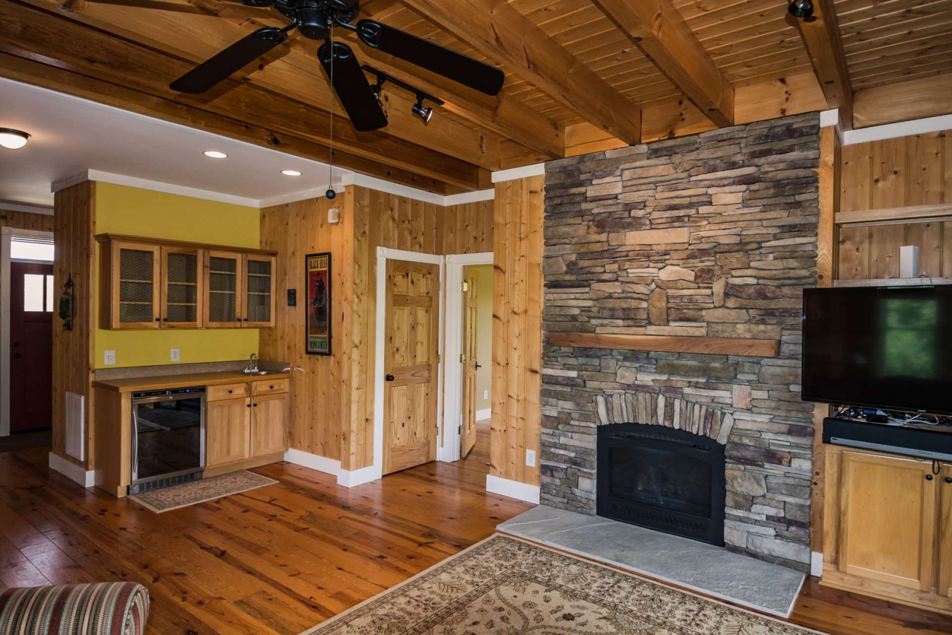 The living area  features a built-in bar area and there is hardwood flooring throughout the home.