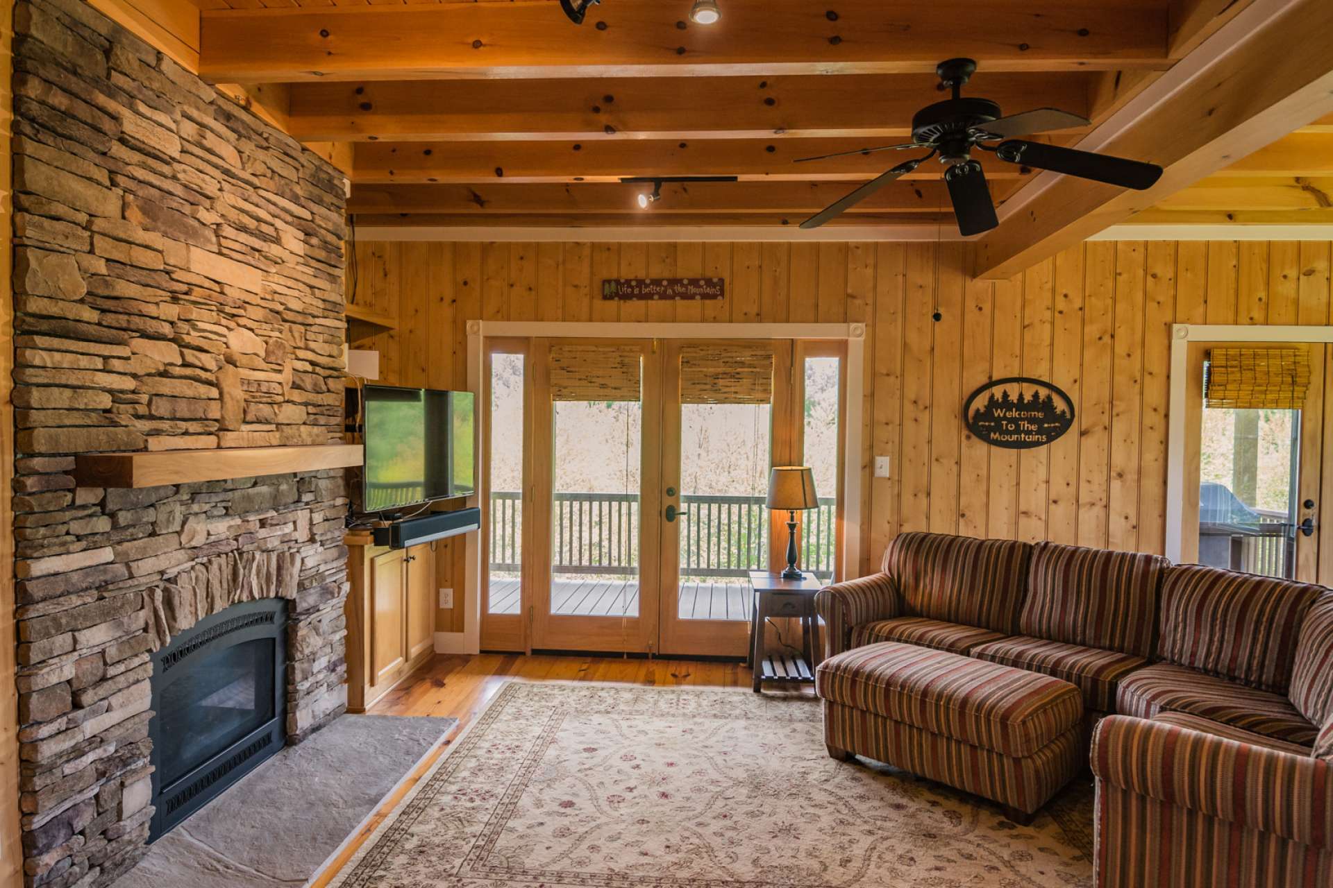 The living area features a stone fireplace with gas logs and easy access to the outdoors.