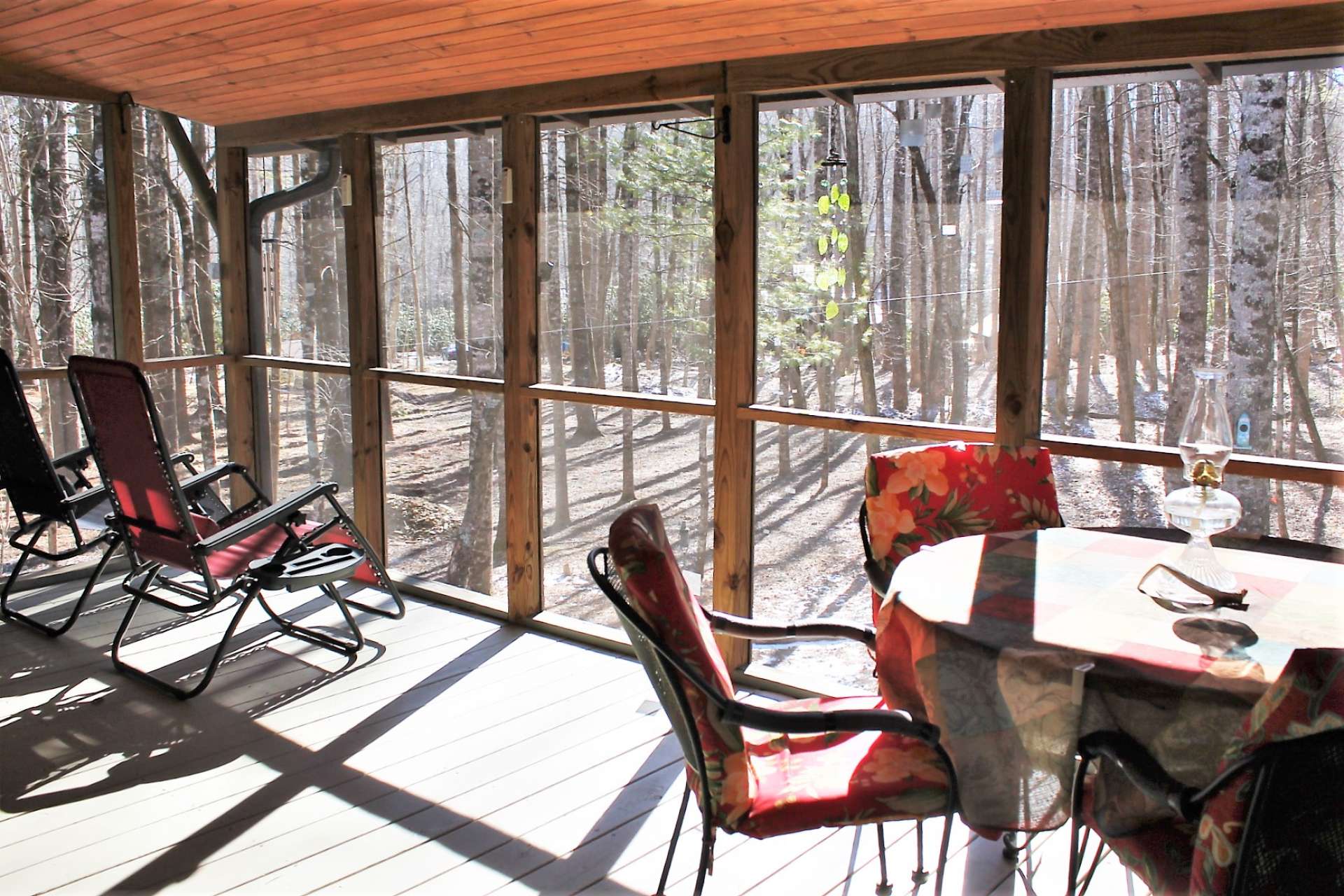 Covered screened porch is a great place to enjoy the backyard's beautiful wooded setting.