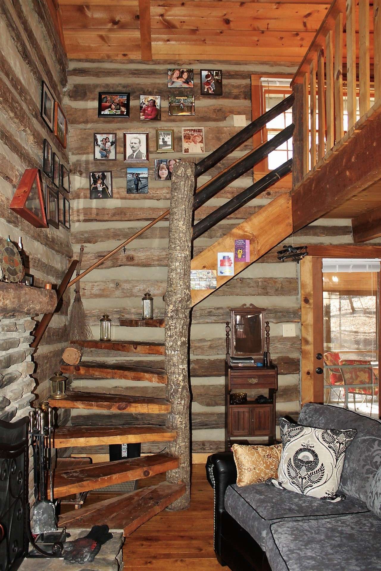 Hand hewn staircase with unique newel post leads to the open loft area.