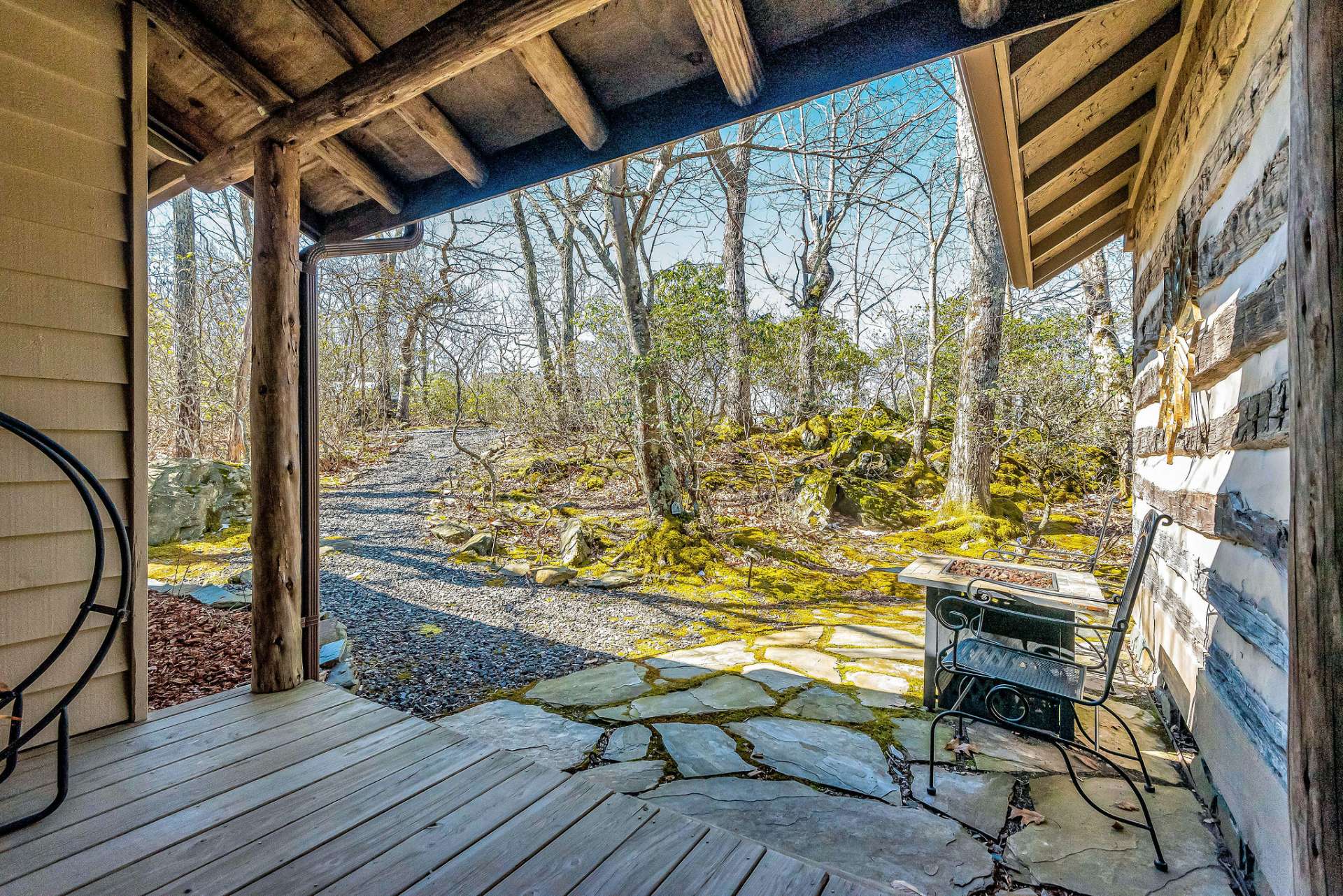 The upper parking area is only a short path to the front door. The front yard features a mossy rock garden, enhancing the authentic mountain ambiance.