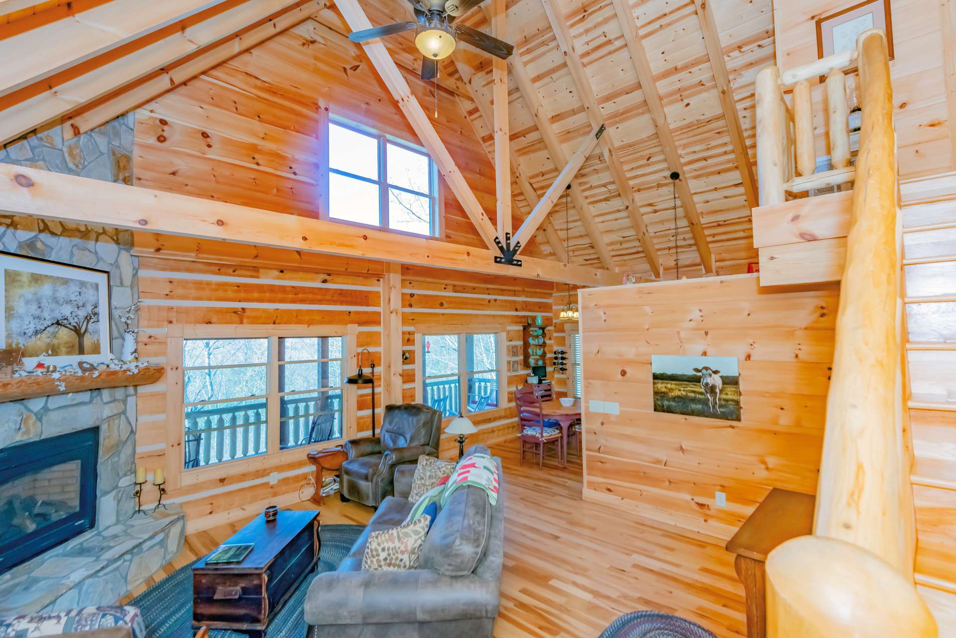 The great room offers high vaulted ceiling with exposed beams, and lots of windows filling the cabin with natural light.