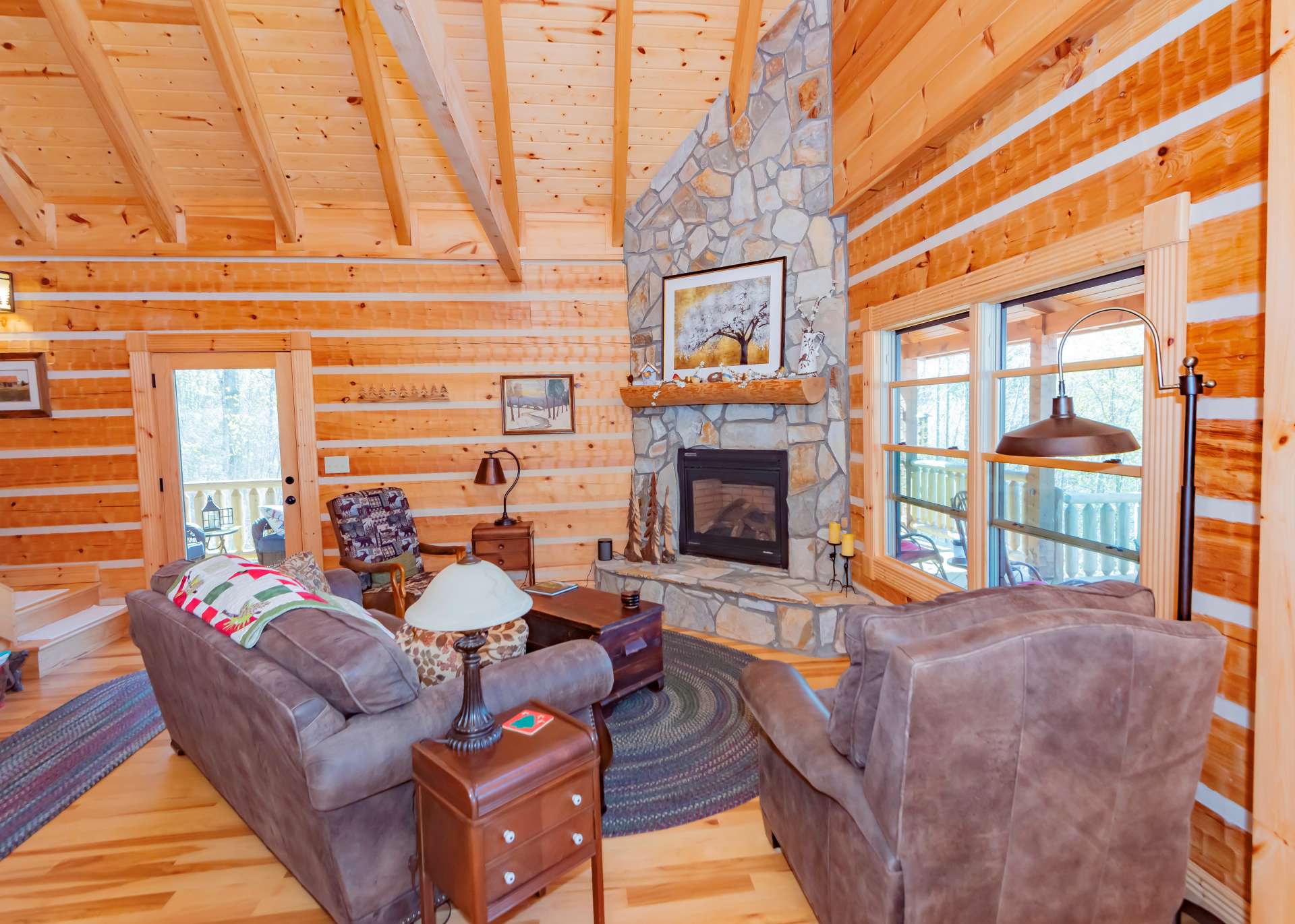 A stone fireplace with gas logs adds to the log cabin experience and adds warmth and ambiance on chilly winter evenings in the North Carolina Mountains.