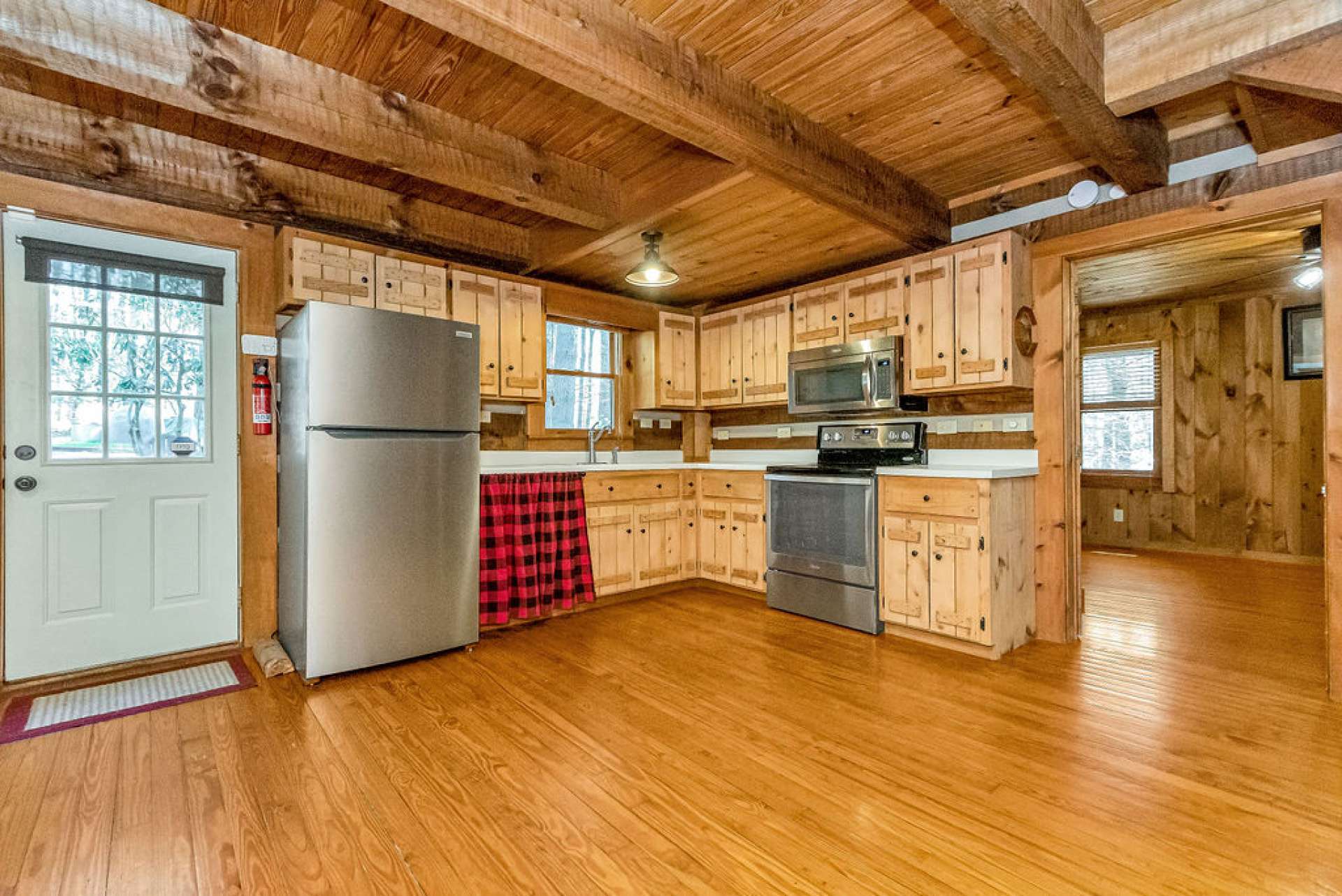 The kitchen features stainless appliances and hand-crafted rustic cabinetry.