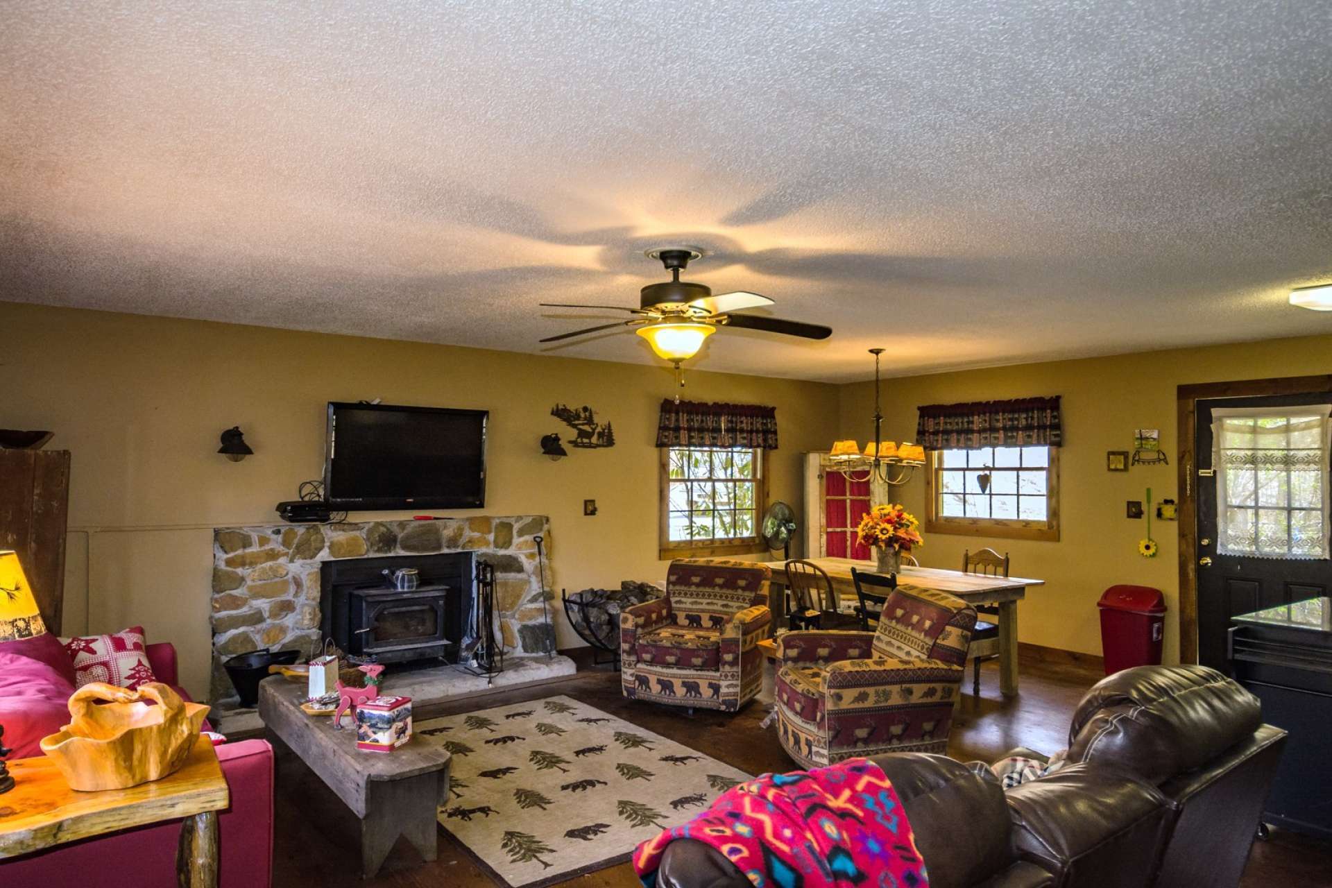The living area features a stone fireplace with a wood burning stove insert to keep the cabin warm and cozy.
